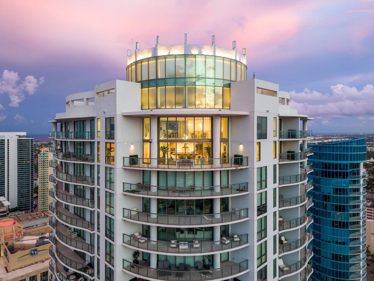 Soaring above Downtown Fort Lauderdale, 100 Las Olas is the city’s most coveted address. This one-of-a-kind, two-story penthouse—the city’s highest—offers 5,281 sq. ft. with 5 bedrooms, 6.5 baths, and 4 parking spaces. Dramatic 20–30 ft. ceilings, walls of glass frame panoramic skyline views, while a fully integrated Magnolia sound system, custom-designed televisions, professional-grade camera security, and a commercial internet network create a sophisticated smart-home environment. The open great room flows to a curved terrace for extraordinary indoor-outdoor living. With top-tier appliances, designer finishes, and world-class amenities steps from premier dining and shopping, this residence defines modern luxury.