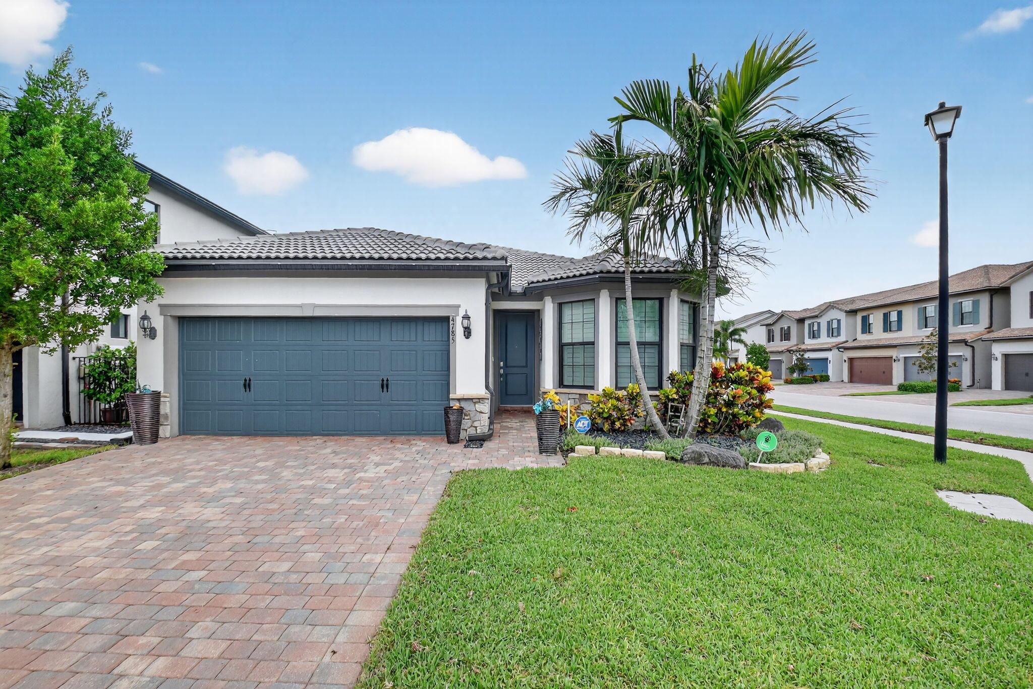 Meticulous 3 bedroom 2 bath home corner lot at the Fields in Lake Worth. Interior upgrades feature natural gas stove & clothes dryer & a gas fired tank-less water heater for on demand service. The kitchen features stainless KitchenAid appliances, granite counters & 42 inch wood cabinets & walk in pantry. Interior amenities offer wood plank tile floors in all rooms, volume ceilings, 8 ft doors, & plantation window shutters, .Screened patio w/ fully retractable 3 section sliding doors, offers corner view of a serene pond. Security system includes a Sonos smart home & a video doorbell. Storm secure impact windows, sliding doors, & garage door . A whole house generator to comfort you. Enjoy a paver driveway & stone fascia for elegance. Two resort style club houses for your enjoyment.
