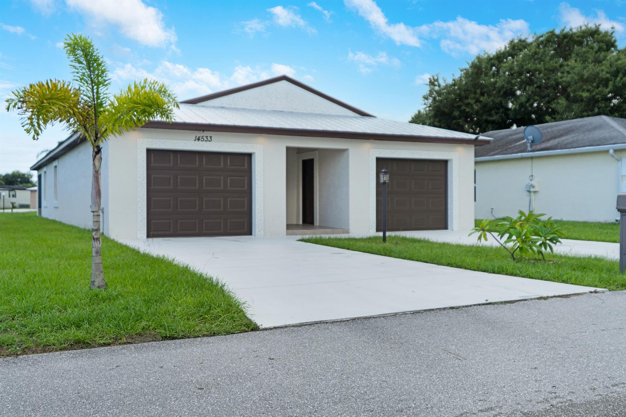 BRING ALL OFFERS! Stunning CBS home built in 2023 and barely lived in. This 3-bedroom, 2-bathroom home is immaculate & full of upgrades. It showcases a metal roof and impact windows, offering durability and peace of mind. Step inside to find upgraded vinyl plank flooring throughout the main living spaces, accentuated by vaulted ceilings that enhance the open floorplan. The kitchen is a chef's dream, with additional cabinetry and space for a wine fridge. The primary suite boasts a coffered ceiling and custom barn door. Relax on the screened-in patio with privacy blinds or enjoy the ambiance of the electric fireplace. The property features an oversized driveway, one-car garage, and a golf cart garage. Electric blinds on the slider add convenience to this meticulously designed home.