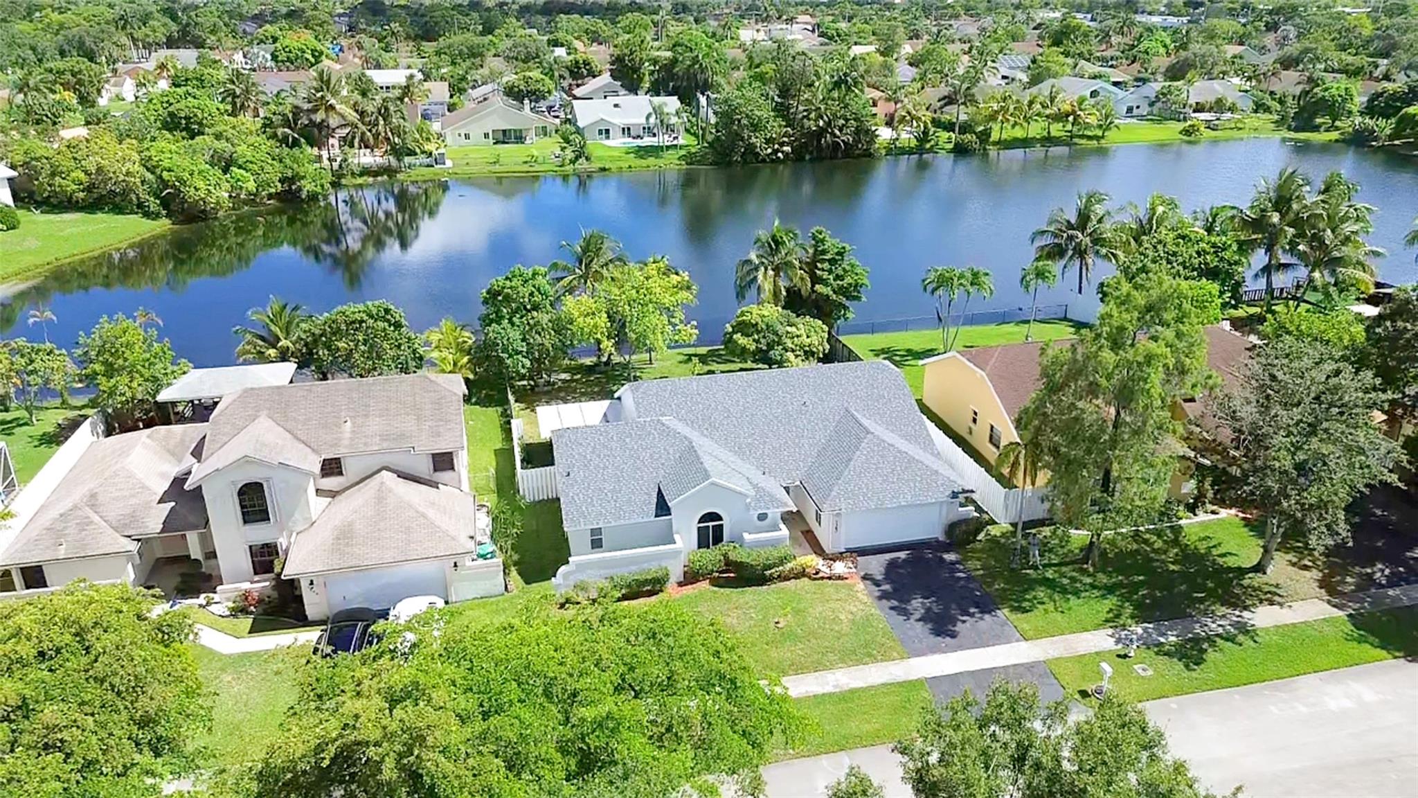 Welcome to your new lakefront oasis in the heart of South Florida! Wake up to serene lake views and enjoy your morning coffee in the spacious backyard surrounded by nature, fruit trees, and exotic wildlife. This 4-bed, 3-full bath house offers an open floor plan with high vaulted ceilings and recently renovated bathrooms, showers, and kitchen cabinets. This home is move-in ready with major upgrades already done for you — including 2024 impact windows and doors, 2024 roof, and a 2025 central AC system. Conveniently located between Sawgrass Expressway and the Florida Turnpike, you’re just minutes from major roads, beaches, airports, and cities. Schedule a showing today to make this beautiful house your new home and experience South Florida living at its finest!