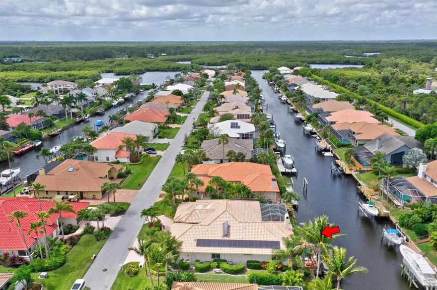 Custom built waterfront home with ocean access that features 4 bedrooms, 2.5 baths, 3 car garage on a deep water canal. Large private dock at 65'. Coral stone tile floors. Granite counter-tops, vanities, and granite walled built-in entertainment in family room with a fireplace. Custom in-ground pool & screened enclosure with a sunning deck and covered lanai. Some impact windows and accordion shutters. Recessed lighting through-out the home. Brick-paver floor inside 3-car garage with high ceilings, and three zones for A/C. Large master bedroom with his and her closets, large bath with separate tub and shower, and his/her vanities. Circular paver drive. 24 hour gated community and lots of wildlife w/ Jonathan Dickinson State Park and the Loxahatchee River bordering the community. Solar too!