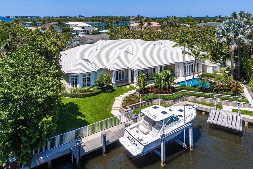 Situated on a spacious double lot over half an acre, this Ocean Ridge estate is a yachtsman's dream. With deeded beach access and membership to the McCormick Mile Beach Club, the residence boasts 118 feet of waterfront and a prime location near the Boynton Beach Inlet, with close proximity to pristine beaches. Built by renowned builder Ciro Gomez, this property spans 6,923 total square feet and features four bedrooms and four and a half bathrooms. The home exudes elegance with classic finishes, a gracious layout, and exquisite water views.  Upon entering, visitors are welcomed by a spacious foyer leading to a formal living room adorned with beautiful tray ceilings, marble floors, and a custom-designed bar. The home integrates progressive design elements and fine millwork, showcasing