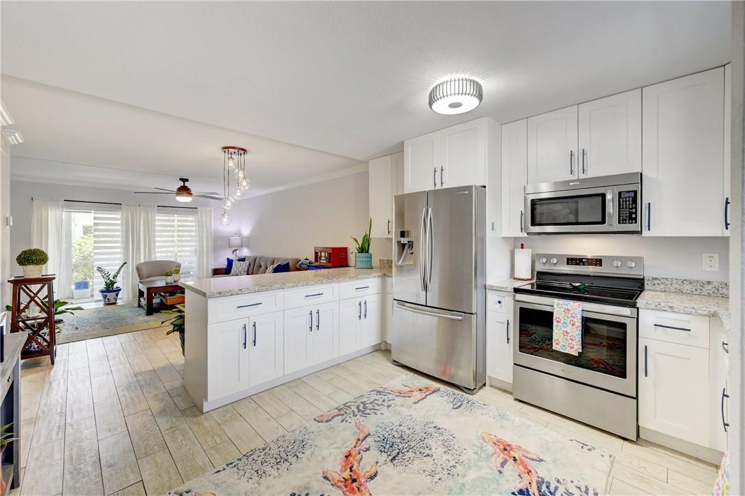 Recently remodeled first floor corner unit featuring open kitchen with white cabinetry and granite countertops and stainless steel appliances. Spacious dining and living room area with sliders leading to a screened patio overlooking garden area. Split plan bedrooms, primary bedroom with walk-in closet. Wood laminate flooring throughout. One parking space directly in front. Large storage closet outside. Close to the beach, restaurants and shopping. Peaceful and well maintained community with 2 pools, barbecue area and shuffle board. No renting allowed. Cash only as per the coop. New sectional couch stays.