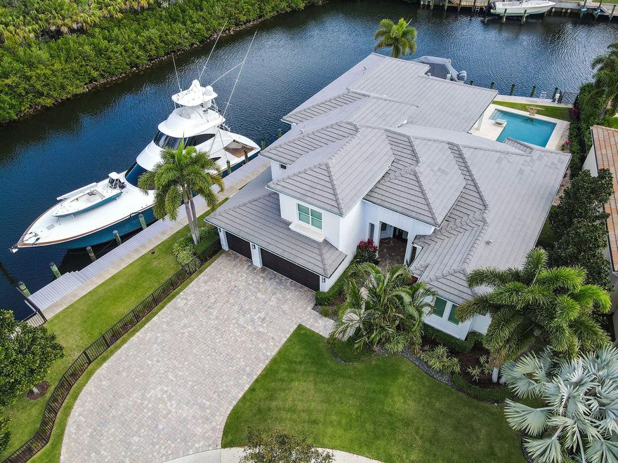 Impeccable custom model home surrounded by 240' of water frontage and nature all while enjoying the privacy of this oversized corner homesite which is situated on a cul-de-sac. This stunning residence features 4 bedrooms plus a loft, 4.2 bathrooms, 3 car garage & dual docks in the exclusive gated community of Frenchman's Harbor. Boasting 2 docks- one of which is 100ft with direct intracoastal access, one that is 70ft with 13,000 lb lift and both with the luxury of no fixed bridges. Meticulously upgraded throughout its 5,359 total square feet, this home delivers the ultimate, opulent waterfront lifestyle of which dreams are made! A sprawling split floor plan offers two ground-floor primary suites and over 3100 sq ft of ground floor living space. Sparkling water views abound from every room! An extended kitchen is perfect for the home chef or entertaining with SubZero refrigerator, 6-top gas WOLF stove, double-ovens, cook's island with sink & sleek quartz countertops. The main primary suite is flooded with natural light from the wall of windows and has direct access to the backyard, coffered ceiling with molding and built out closets. The second primary has its own side entrance and boasts high-end fiber free carpets, large en suite bathroom with double/separate vanities, spa tub, walk-in shower, separate W.C and a water view. An additional cabana bath is on the ground floor allowing for ultimate comfort while transitioning into outdoor living. An extended lanai offers alfresco relaxation no matter the weather, and an outdoor grill, kitchen, bar and television were added. A large pool deck, saltwater pool and raised spa can be enjoyed as you watch the boats go by. The only plot in Frenchman's Harbour without "zero-lot-line", this home has extended side yards and is completely fenced except for the front yard. A large paved driveway offers plenty of parking, as does the 3-car garage which has epoxy flooring, tankless water heaters, electric car charger, new upgraded split AC system, insulated garage doors, gypcrete floors, icynene insulation throughout and the homes water-filtration softener. Truly, no stone has been left unturned- reach out today and discover for yourself the turn-key, waterfront lifestyle that awaits. Ideally located minutes from the Juno Beach pier, Frenchman's Harbor is a short ride to the world class shopping and dining along the PGA corridor, and close proximity to the Jupiter Inlet and the Palm Beach Inlet via boat. The community offers residents a 24/7 manned gate entry, pool, and private dock with each residence.