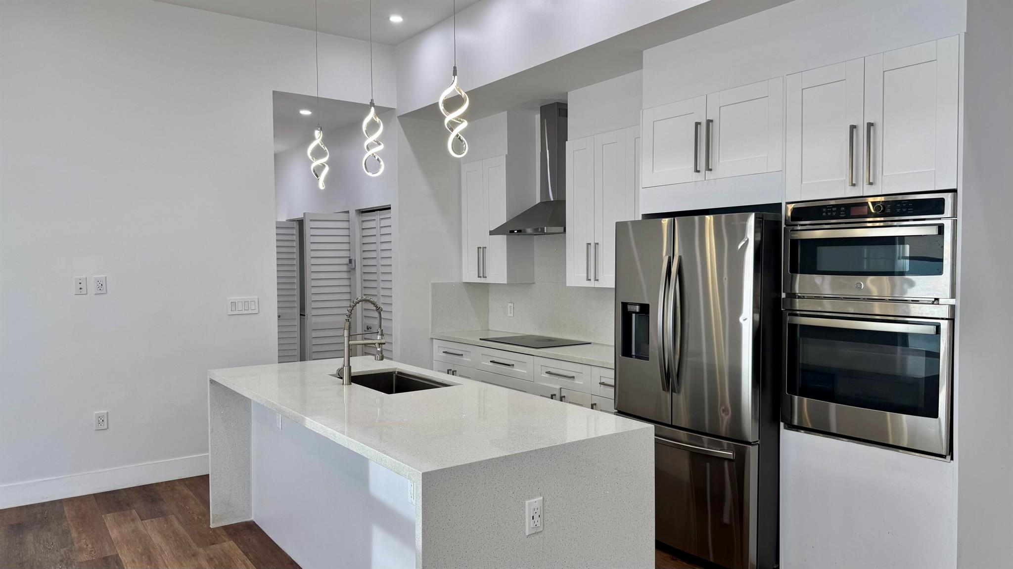 Welcome to this beautifully finished 2-bed, 2-bath home in a modern duplex in the heart of Hollywood. Enjoy a chef-inspired kitchen with quartz countertops, waterfall island, induction cooktop, 2 built-in ovens, and USB outlets. Features include high ceilings, designer lighting, in-unit washer & dryer, private garage entrance, and EV charger. The primary suite offers a walk-in closet and private bath. Bathrooms include LED-lit mirrors and premium tile. Enjoy a fenced backyard, perfect for outdoor relaxation. Close to Downtown, I-95, and the beach.