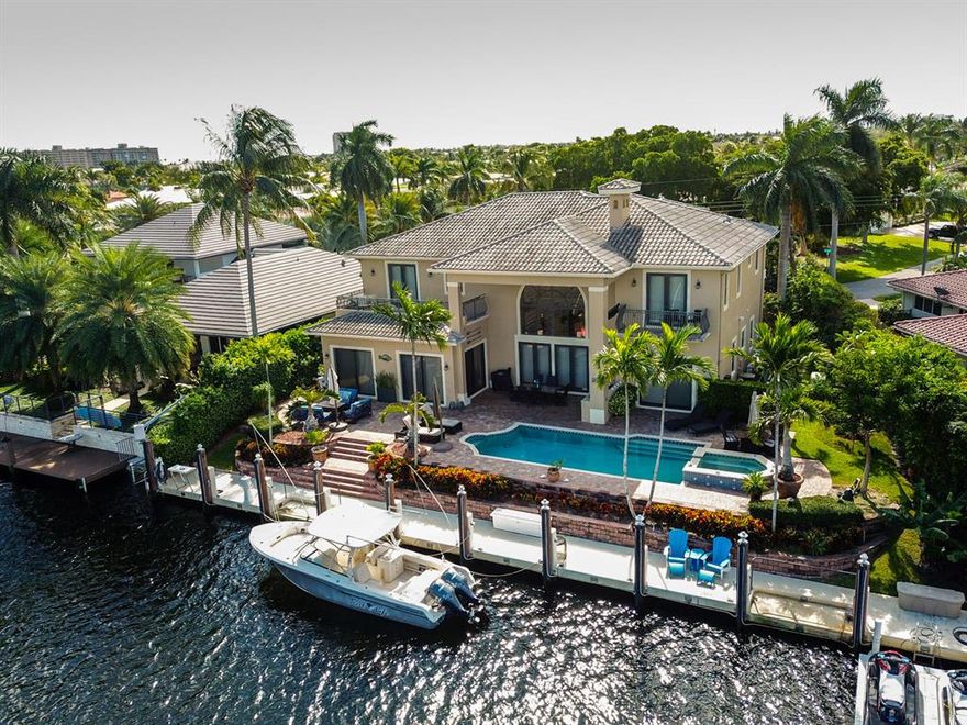 A waterfront dream on the extra wide North Grand Canal! Stunning 5 br, 5 ba estate home with 105 feet of concrete dockage in sought after Lighthouse Point. On the first floor the home impresses with an atrium foyer and living room with gas fireplace, a wet bar, a private 2 br, 1 ba suite, 300 gallon saltwater fish tank and an oversize chef's kitchen with a gas stove, opening into the dining room and family room. The upstairs split floorplan, offers a large master suite and 2 en-suite bedrooms, upstairs laundry room and elevator. Panoramic water views and gorgeous marble and hardwood floors throughout. The outdoor area is perfect for entertaining with a large pool, hot tub, covered patio and summer kitchen. The home comes complete with a brand new generator and impact windows.