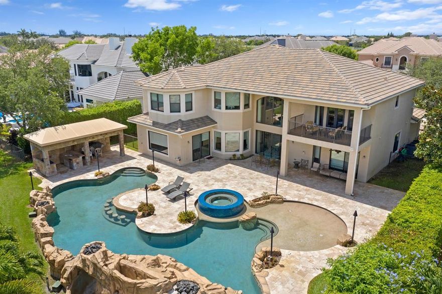 Stunning and spacious estate in the exclusive community of Equus. Boasting 5 br/5.5 baths, 32'' square marble tile, and highly detailed custom woodwork throughout, this 4600 sf stately home sits on over 1/2 acre of land and includes an adjoining bonus lot which can accommodate a horse and barn. The home is spacious and bright inside, featuring large rooms with high ceilings and a huge, custom gourmet kitchen with lots of cabinet space. To the rear of the house is an amazing outdoor entertainment area, including a large barbecue grilling area and a stunning custom pool, complete with a rock wall backdrop and cascading waterfall!