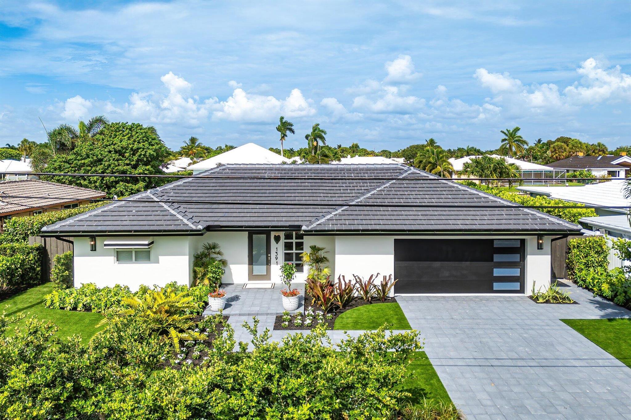 Meticulously renovated West Indies Chic waterfront home on East Boca's El Rio natural waterway with ocean access under two fixed bridges. Features split-bedroom layout, exposed beam ceilings, fully retractable sliders, tile throughout, and custom finishes. Gourmet kitchen with Bosch appliances, leather-finish stone counters, concealed microwave, and hot water dispenser. En suite primary with dedicated A/C, soaking tub, French doors to pool, and water views. New roof, windows, driveway, garage, landscaping, and generator-ready panel. Enjoy outdoor living with a covered patio, retractable screens, 80' waterfront, and 20' private deep-water dock. Minutes to pristine beaches, fine dining, and shopping. A rare turnkey opportunity!