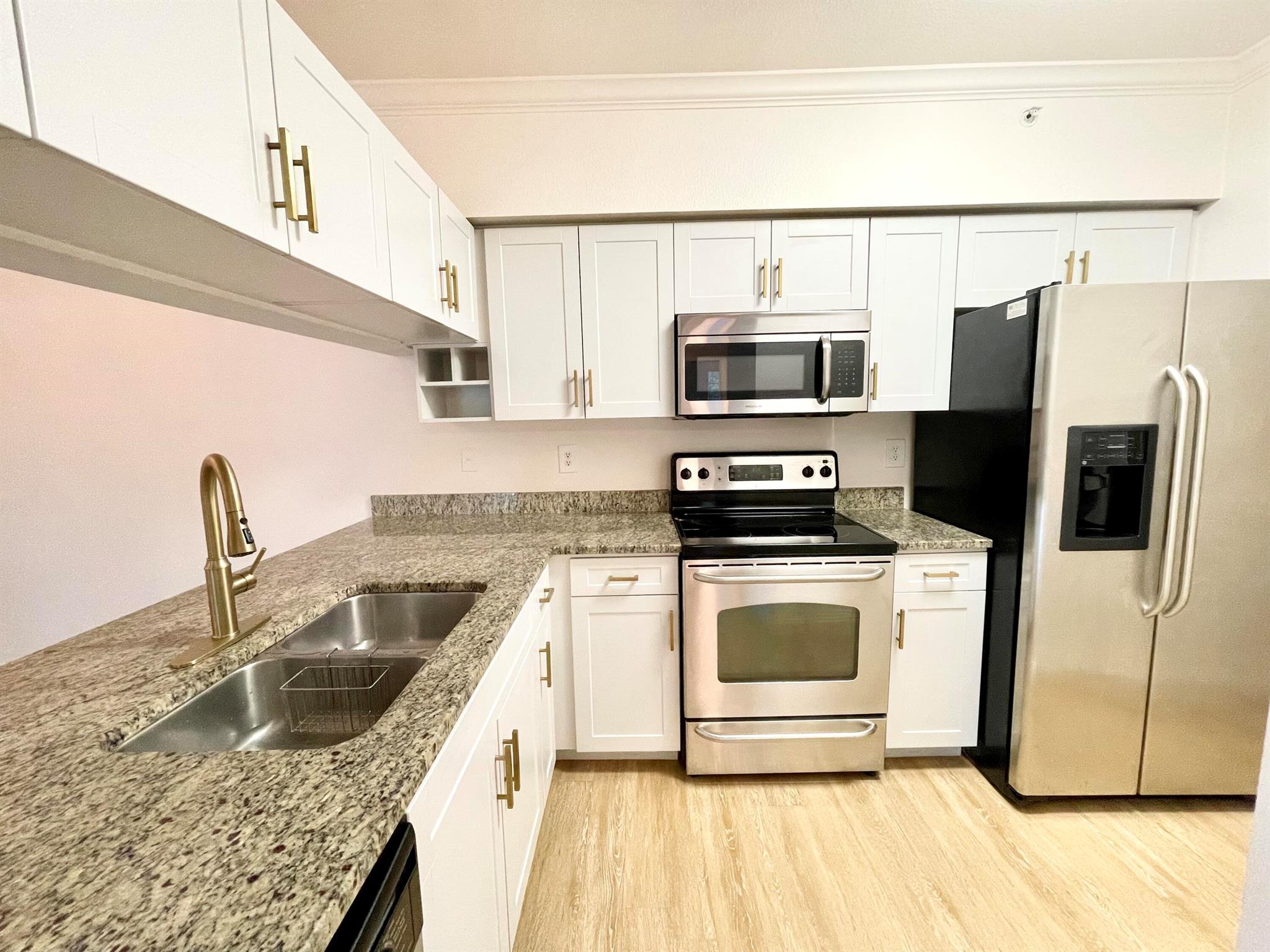 Beautifully updated 2BR/2BA condo with rare 1.5-car garage in the building! Water, cable TV, Resort Style Living included in rent! Vinyl plank flooring throughout, light neutral paint, and impact windows/sliders. Upgraded kitchen with granite countertops, white cabinetry, SS appliances, and modern fixtures. Both bedrooms are spacious with walk-in closets. Primary bath features marble vanity. Private in-unit laundry.Villas at Emerald Dunes is a gated, resort-style community with patrolling security, 2 pools, 2 fitness centers, tennis, billiards, clubhouse, and business center.Unbeatable location: 6 miles to the beach, 5 miles to Downtown & The Square, 4 miles to PBI Airport. Ideal as a primary home, investment, or seasonal getaway!