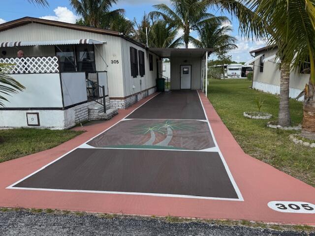Welcome Home to $0 LOT LEASE, & only $250 monthly fees, for this lovely manufactured home in the Whispering Creek 55+, CO-OP community. The spcacious, well maintained home is turn-key ready, and rests on an oversized lot, minutes from the blue water beaches of Ft Pierce, & surrounded by beautiful, mature swaying palm trees. The sizeable 2 Bdr- 2 Ba. boasts indoor laundry, an extended carport, a handy storage shed, and rests directly across from a peaceful common green space, with no neighbors to the east. You'll love the beaurtiful balmy breeze and extra privacy from your custom glider on the lovely oversized porch. An additional bonus... engineered hurricane anchors & concrete footings (some over 1000 lbs) secured by 19 additional stabalizing lines for enhanced storm protection!