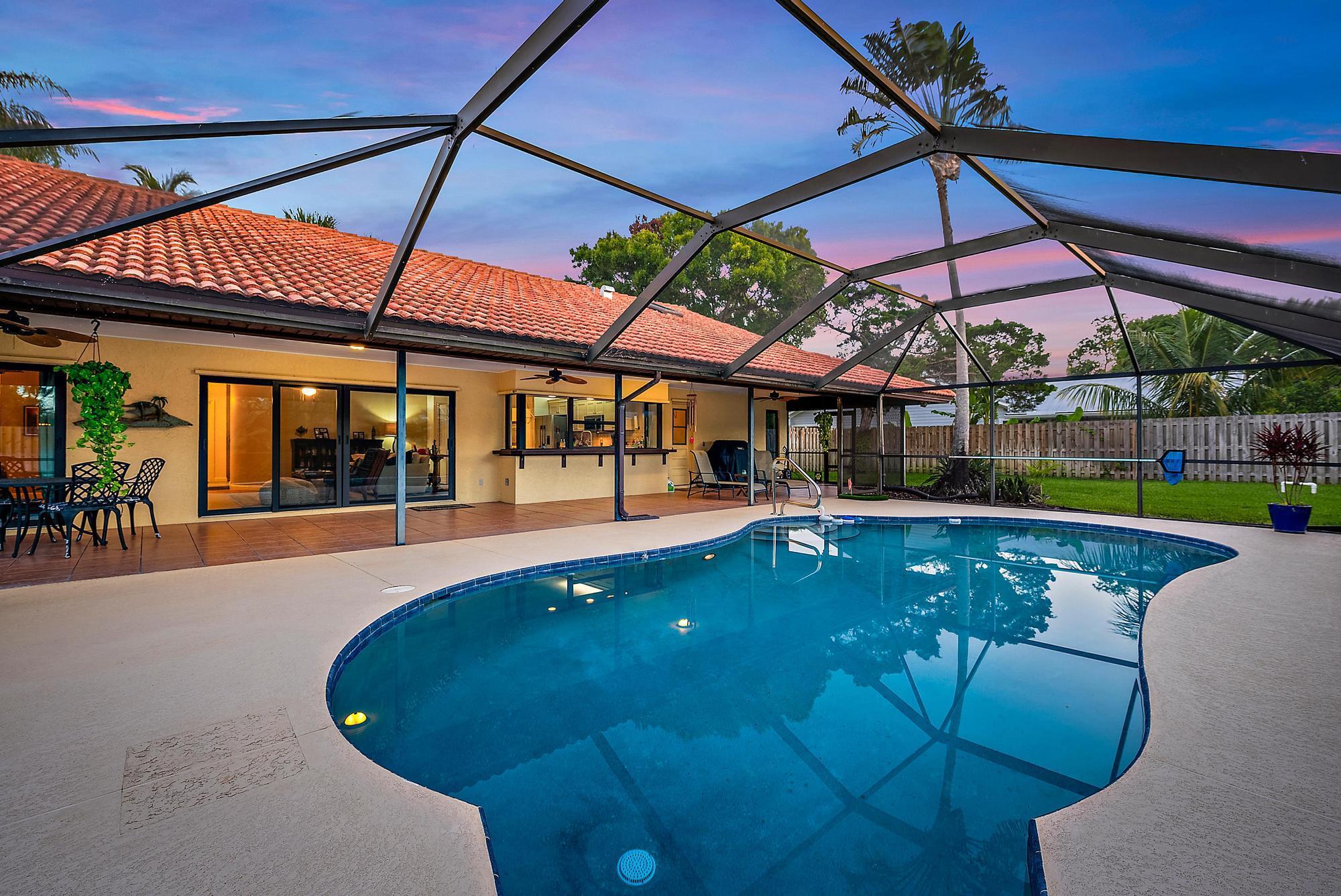 Bring your boat!! Beautiful 3-bedroom CBS pool home on a 0.35-acre lot with lush green space and privacy. Step inside and admire the white oak hardwood floors that flow seamlessly throughout. The kitchen features newer appliances, including a Fisher & Paykel refrigerator, a Bosh dishwasher, and leathered granite counters. The pass-through window to the lanai is perfect for entertaining and relaxing by the pool. Other upgrades include impact windows, a 2020 roof, and a new fence.