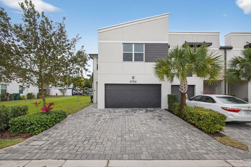 Built in 2022, this 3-bedroom, 2.5-bathroom townhome is located in the gated Enclave at Mangonia Park and offers spacious living. The open-concept layout features high ceilings, abundant natural light, and a modern kitchen with stainless steel appliances, ample cabinetry, and a center island overlooking the main living area. Upstairs, a versatile loft provides additional living or flex space. The primary suite includes a private ensuite bath, while two additional bedrooms share a full bathroom. Additional features include an upstairs laundry area and a 2-car garage with extended driveway offering additonal parking. Conveniently located near the Tri-Rail, Palm Beach International Airport, I-95, Brightline station, downtown West Palm Beach, Palm Beach Outlets, and area beaches.
