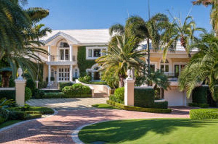 Private Waterfront Estate.  One acre of manicured gardens and lawns leads to this magnificent direct lakefront home unusually sited on a peninsula. Features 5BR/guest house/5 car garage. Wrap terraces on each floor overlook the most expansive south/west views of the Intracoastal. Gated privacy. Deeded beachfront and  150' dock.