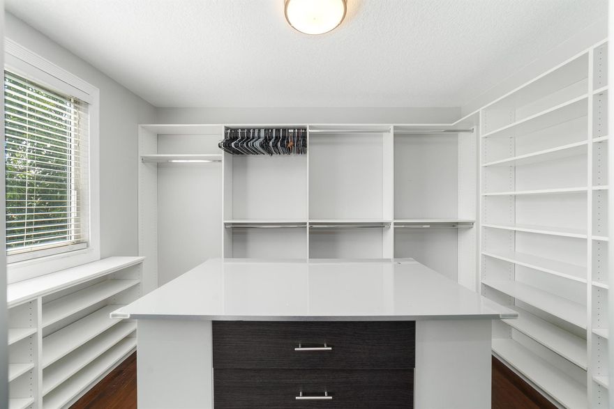 Tucked away in Coral Lake Estates, this charming 3-bedroom, 2.5 bath home offers 2,036 sq. ft. of inviting living space, highlighted by tranquil canal views and a backyard that feels like your own private nature retreat. Soaring ceilings, impact windows and doors, and abundant natural light from generous windows create a bright and airy atmosphere throughout. Downstairs, tile flooring provides durability and style, while warm wood flooring upstairs adds a cozy touch. The thoughtfully designed kitchen opens to a spacious covered patio complete with a summer kitchen, ideal for relaxing or entertaining guests. One of the home's standout features is the primary suite's closets, yes, plural, including one that's the size of a bedroom.