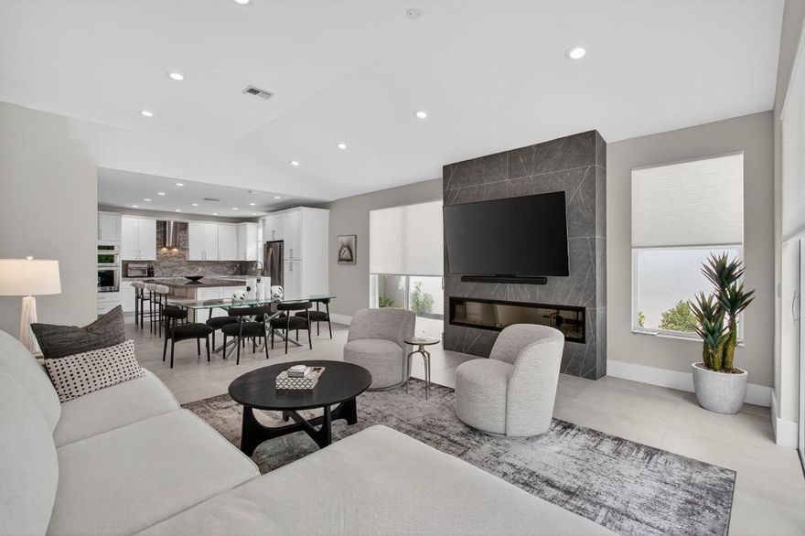 Discover this beautifully renovated single-story 3-bedroom, 3-bath home in the highly sought-after village of Laurel Pointe in Broken Sound Country Club. Designed with modern elegance, this residence features smooth walls, porcelain tile floors, and vaulted ceilings throughout. The open-concept kitchen and living room create a welcoming space for everyday living and entertaining. The kitchen showcases white cabinetry, a spacious center island with abundant storage, and a built-in beverage cooler. Retreat to the primary suite, complete with vaulted ceilings, a large walk-in closet, and a luxurious en suite bath featuring a large skylight, free-standing soaking tub, and frameless glass shower. Two additional bedrooms and baths offer comfort and privacy for family or guests. Step outside to your enclosed backyard oasis with fresh landscaping and newly finished patio decking, perfect for outdoor entertaining. Enjoy the convenience of being within walking distance to the recently renovated, heated community pool. This move-in-ready home combines sophisticated style, indoor-outdoor living, and an ideal location within Broken Sound Country Club.