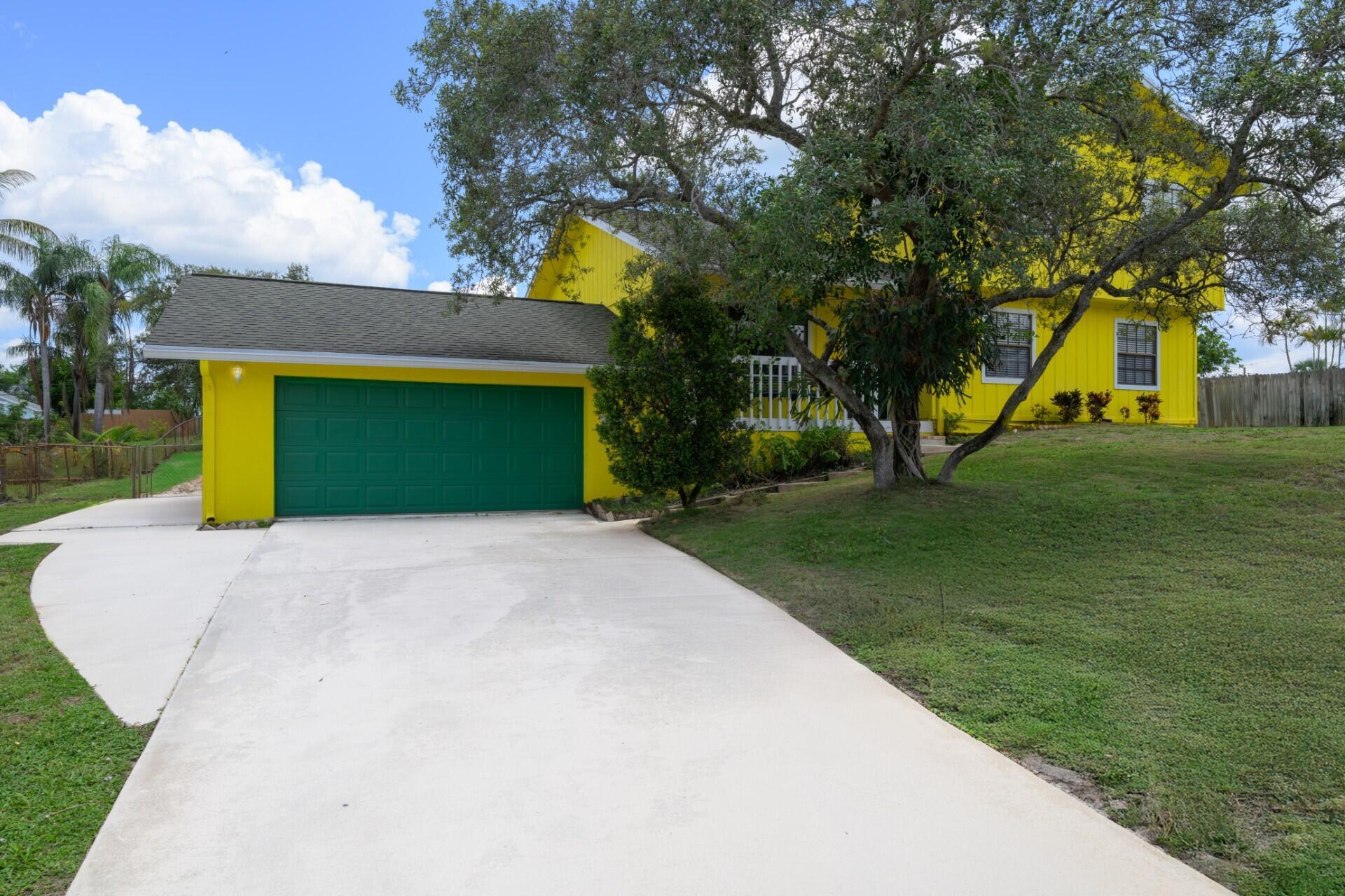 Fantastic Tri-Level POOL home on 0.5143 Acres in Beautiful Hobe Sound in Papaya Village/ Hobe Hills. This fantastic home features So much Charm w/Vaulted Tongue & Groove Cedar Ceilings, Wood Laminate Flooring, 3-Large Bedrooms 2.5-Baths & a Den! Huge oversized 2-Car Garage & a BASEMENT!! This home sits way up on a hill! Newer A/C's & Water Softener System. Yard is Fully Fenced w/Large Trees & Plenty of room to build a detached garage or in-laws suite! Come relax in the Large Free Form Pool w/Tile Turtle Inlays & Lg Screened in Patio. Just a short distance (3 min) to the Hobe Sound Beach, I-95, Specialty Dining & Shopping! Just a block away from Jonathan Dickinson State Park. Jimmy Graham Boat Ramp, The Pine School & HS Elem. All this in a NO-HOA community! Bring your toys!!