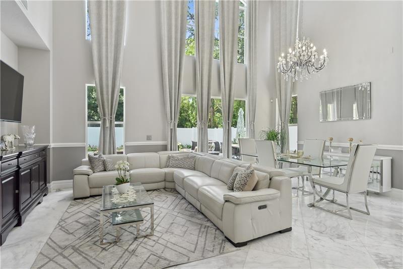 MOVE IN READY 4 BEDROOMS+LOFT. WHOLE HOUSE GENERATOR! POOL! Grand entrance with spiral wrought iron stair case WITH 10FT CRYSTAL CHANDELIER FROM EUROPE and soaring 21ft ceilings, 2019 updates include :MARBLE flooring, gourmet kitchen with upgraded all wood cabinets with pullouts. Granite slab counter tops and backsplash. High End KITCHEN AID SS Appliances (2019). 2019 A/C, gas tankless water heater, paint inside and out , gutters, LED lights, Legrand outlets and light switches! 2 primary bedrooms - one downstairs and one upstairs with marble bathrooms, all wood cabinets and granite countertops! 2019 refinished diamond bright 32x12'' pool perfect for laps with new glass tile and 1500 SQ FT marble pavers and privacy fence! 2021 pool pump! ACCORDION SHUTTERS!