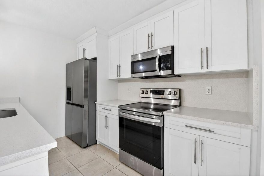 Stunning like-new townhome featuring a fully remodeled interior with large-format tile and luxury vinyl plank flooring throughout. The showstopping kitchen boasts granite countertops, custom white shaker cabinetry, and stainless steel appliances. Spacious upstairs bedrooms open to private balconies, while the fully fenced courtyard provides a rare and intimate outdoor retreat. Community amenities include a pool and fitness center. Ideally located with easy access to I-95, minutes from Downtown West Palm Beach and Wellington.