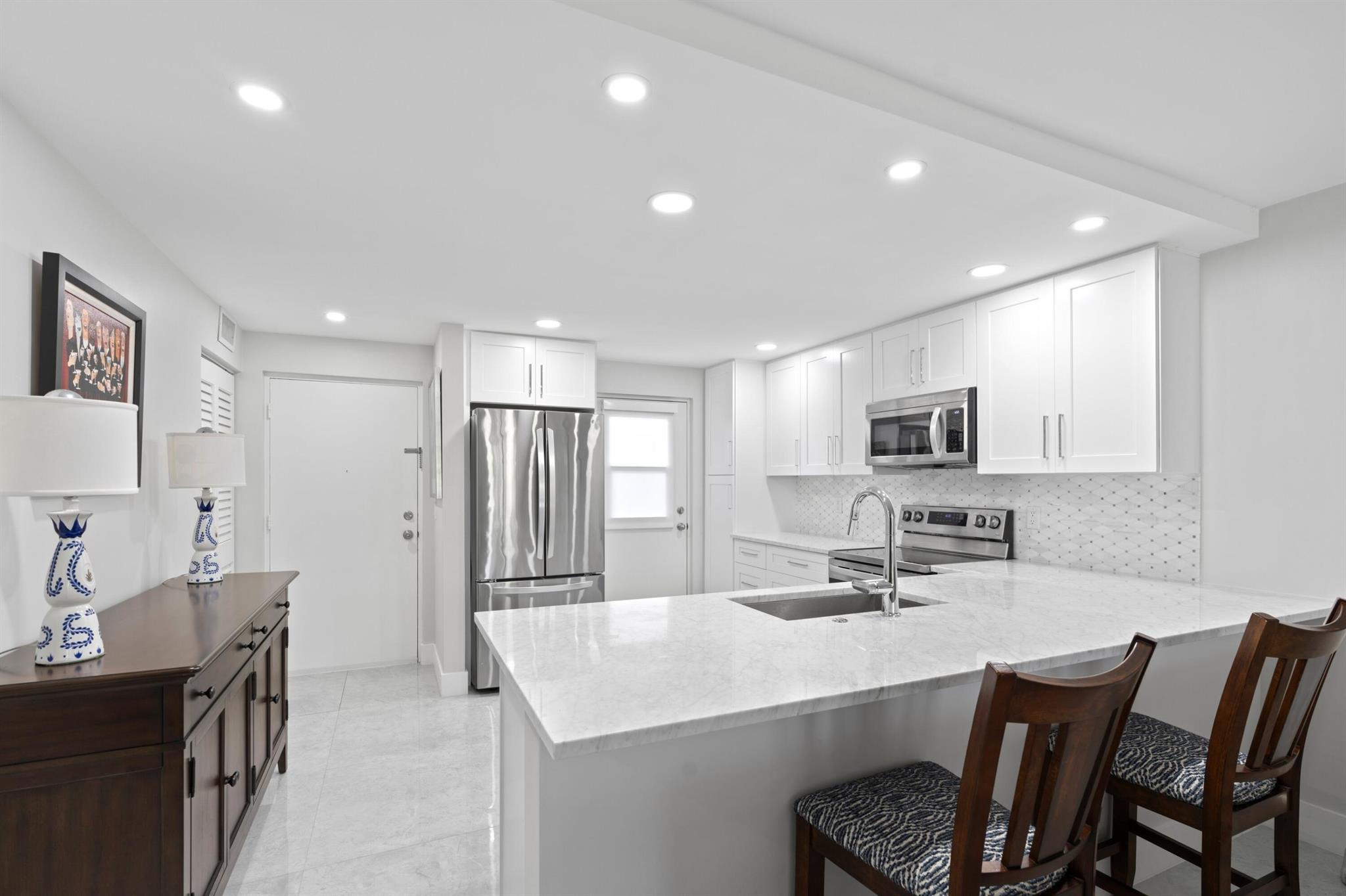 GORGEOUS CONDO | NEW ROOF 2023 | NEW AC 2021 | NEW WH & COMPLETE HURRICANE IMPACT WINDOWS 2022 | FIRST FLOOR | Desirable East Boca Raton Location of Boca Teeca! Minutes to Beach, Downtown Mizner Park, Popular Atlantic Avenue & I-95. Peaceful Garden Views | Bright Open Floor Plan | Recessed Lighting | Private Screened Patio | Washer & Dryer in Unit! Updated Eat-In Kitchen | 42'' White Shaker Cabinets | Quartz Countertops & Tile Backsplash | S/S Appliances | Pantry | Barstool Seating | Primary Bedroom with Walk-In Closet and En-Suite Bath | Both Bathrooms with Glass Walk-In Showers | Patio Sliders w/ Electric Blinds | Community Pool & Assigned Dedicated Parking Spot Out Front | Park Being Built | Recent Building Exterior Upgrades | Cable/Internet Included | A+ Rated Schools!
