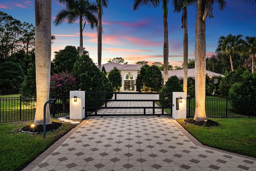 Nestled on 1.35 acres in the prestigious Sherbrooke Estates, this custom-built 5-bedroom, 3.5-bath home is a rare gem that seamlessly blends modern design with timeless character—something you don't often find in South Florida. From the moment you arrive, the property impresses with its private gated driveway, fully fenced perimeter, and meticulously designed landscaping, featuring tropical plants, bougainvilleas, and custom lighting that transforms the exterior into an enchanting oasis.

Step outside, and you'll discover over 2,000 sq. ft. of outdoor living space ideal for entertaining or relaxing in privacy. The expansive veranda overlooks the sparkling pool and features an outdoor kitchen, TV, and newly installed retractable hurricane-rated sunscreens for shade and comfort. Whether hosting guests or enjoying a quiet evening, this space is the ultimate retreat.

Inside, the home dazzles with a thoughtfully designed 3-way bedroom split for optimal privacy. Soaring ceilings and an open-concept layout create an inviting flow between the living areas, including a spacious living room, dining room, breakfast nook, and family roomall with views of the pool and lush backyard. The master suite is a luxurious sanctuary with custom closets and a beautifully renovated en-suite bath, while the additional bedrooms provide ample space for family or guests.

No detail has been overlooked in the extensive upgrades completed over the last three years. The home boasts PGT Low-E hurricane-impact windows and doors, a new electrical panel and wiring, a tankless water heater, and hurricane-rated garage doors. The kitchen has been entirely reimagined with custom cabinetry, Calacatta countertops, pull-out storage, and high-end Italian appliances from Fulgor Milano. Bathrooms have been remodeled with frameless shower doors, Calacatta countertops, and modern fixtures. Additional touches include custom closets in every room, new flooring and baseboards, updated interior and exterior paint, and designer lighting and drapery throughout.

Even the garage has been elevated, featuring epoxy flooring, a mudroom, and a spacious, renovated laundry room with quartz countertops and custom cabinetry. Every corner of this estate exudes quality and attention to detail.

Located in one of Palm Beach County's most sought-after communities, Sherbrooke Estates offers a serene lifestyle just minutes from shopping, dining, the Turnpike, and top-rated schools. Opportunities like thisa fully updated home on a sprawling, private lotdon't come around often. Don't miss your chance to make this extraordinary property your own!