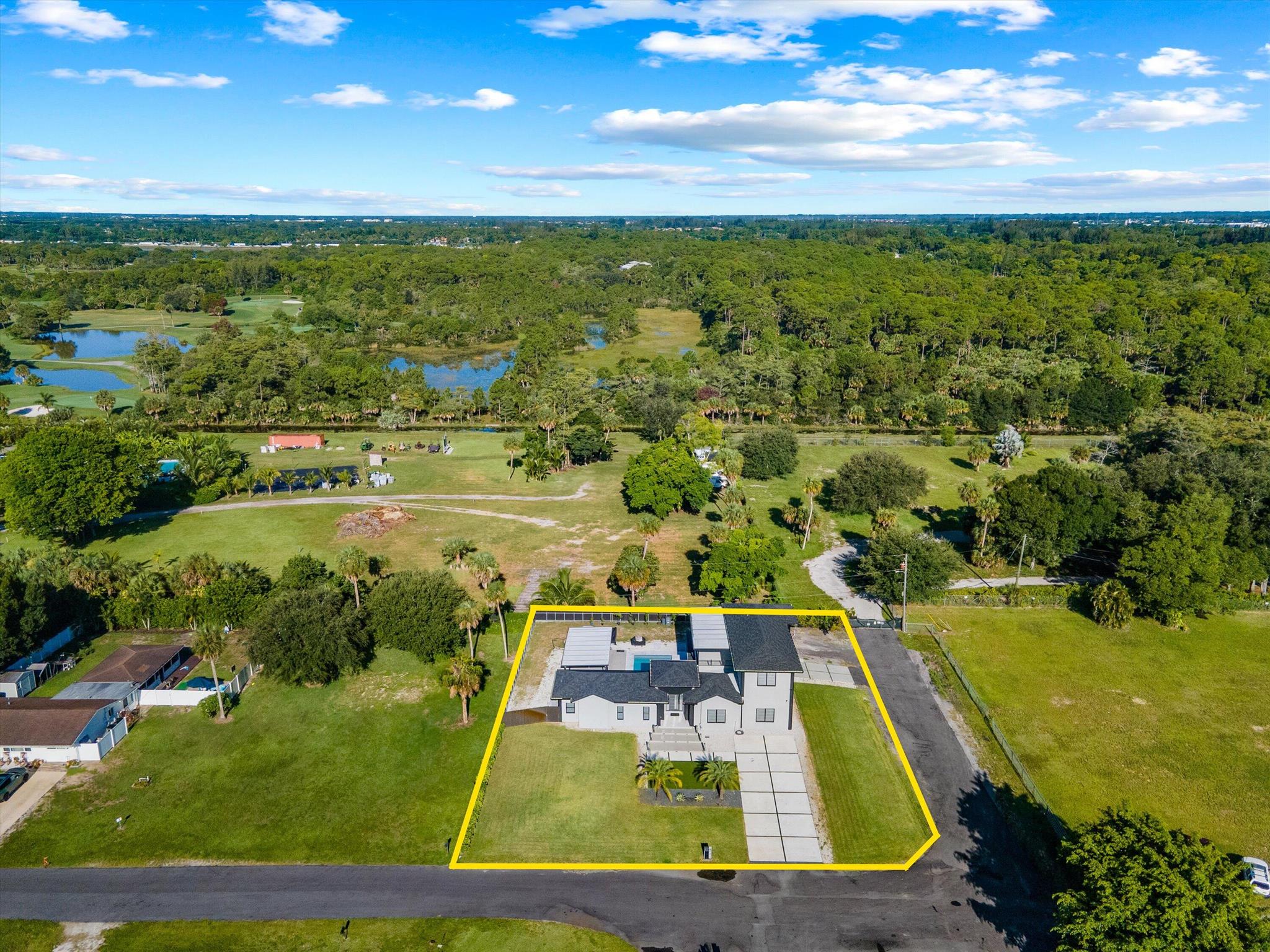 Experience modern living in this newly constructed, stunning 2-story estate in Palm Beach Farms. Set on a generous 0.61-acre lot, this home offers 4 spacious bedrooms, 3 luxurious bathrooms, a dedicated office upstairs, and a 1-car garage. Paved access roads provide added convenience, while the main-floor primary suite is perfectly designed for today's lifestyle. Impact windows and a full security system add comfort and functionality. A large balcony overlooks the lush grounds and pool, offering a peaceful retreat. Enjoy resort-style living in your private backyard oasis, complete with an oversized pool and a pavilion with a full summer kitchen--ideal for entertaining.