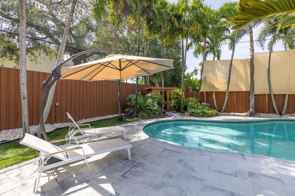 Stylish & sophisticated Mid-Century smart pool home in Wilton Manors. 2 bedroom's feature ensuite bathrooms, primary bedroom suite has large sitting area. Custom upgrades include design by Allied Kitchen, featuring Sub-Zero, Wolf & Cove SS smart appliances. Updated bathrooms, Metal roof w/ solar panels that runs the entire home, storage batteries & 2 high voltage car chargers. All impact windows & doors, Brazilian hardwood floors, newer central ac w/ UV air sanitation, Waterlux whole house water filtration system, alarm, Bose surround sound throughout the home. The private custom landscaped backyard is like a 5-star resort featuring a large heated saltwater pool, pavers, landscape lighting, infrared sauna, power retractable awing, well water irrigation, & maintenance free artificial turf