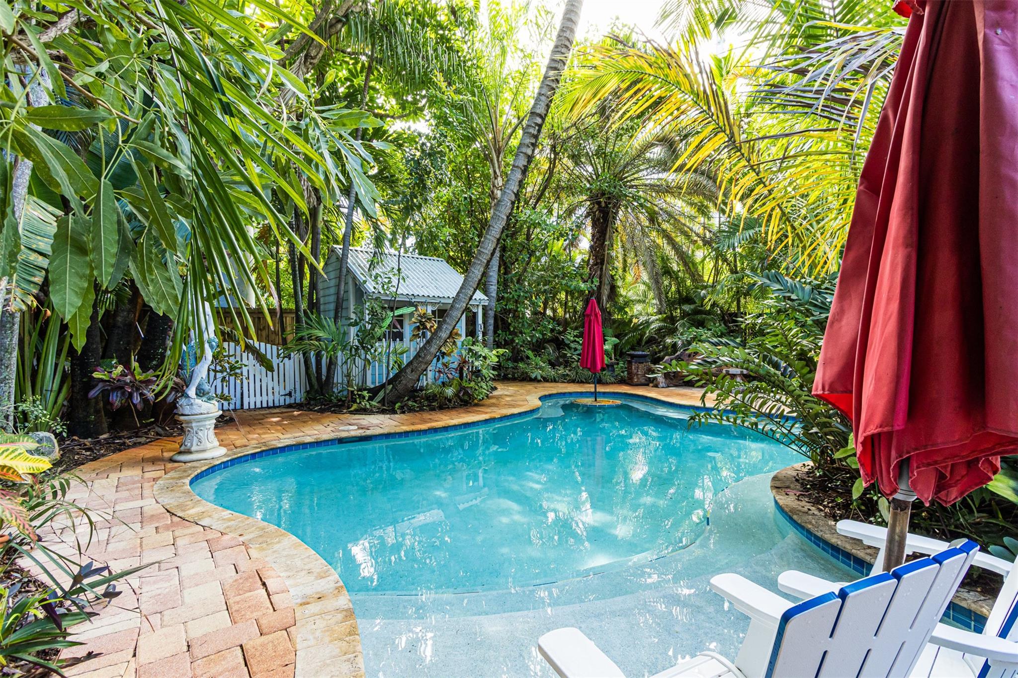 As you enter this unique home, you will be captured by its character & cool vibe and at that moment you will know that you have found that Special place. Some upgrades include New Roof in 2020, New Oven in 2025, New Pool Pump in 2025, New A/C motor in 2025. Vintage Woodwork to the doors & floors. Dade County Pine flooring in Dining area, Hallway & Kitchen. Decorative Fireplace with 1924 Bricks on Hearth. Acid-stained concrete Floor in Living Room. Dry Bar with Wine Cooler. Separate Tool Room. Huge Walk-in Pantry. Laundry Room. Cozy outdoor Fireplace in Lanai. Enchanting grounds & Huge Patio area. Saltwater Pool with umbrellas & seating areas. This area gives total privacy and seclusion with beautiful exotic plants & flowers creating an amazing tropical paradise. Come see and fall in LOVE!