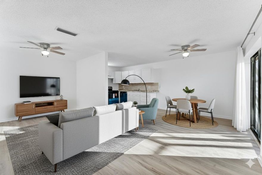 Welcome to this townhouse featuring new vinyl plank flooring and fresh neutral paint throughout, creating a bright and modern canvas. The open-concept layout seamlessly connects the living and dining areas to a stylish kitchen equipped with crisp white cabinetry, granite-look countertops, and stainless steel appliances.  Enjoy effortless indoor-outdoor living with large sliding glass doors that open to a private, tiled screened-in patio—perfect for relaxing or entertaining. The two-story design offers privacy with bedrooms tucked away upstairs, while the main level remains open and airy for daily life. Whether for a primary residence or investment, this home offers a clean, contemporary aesthetic waiti