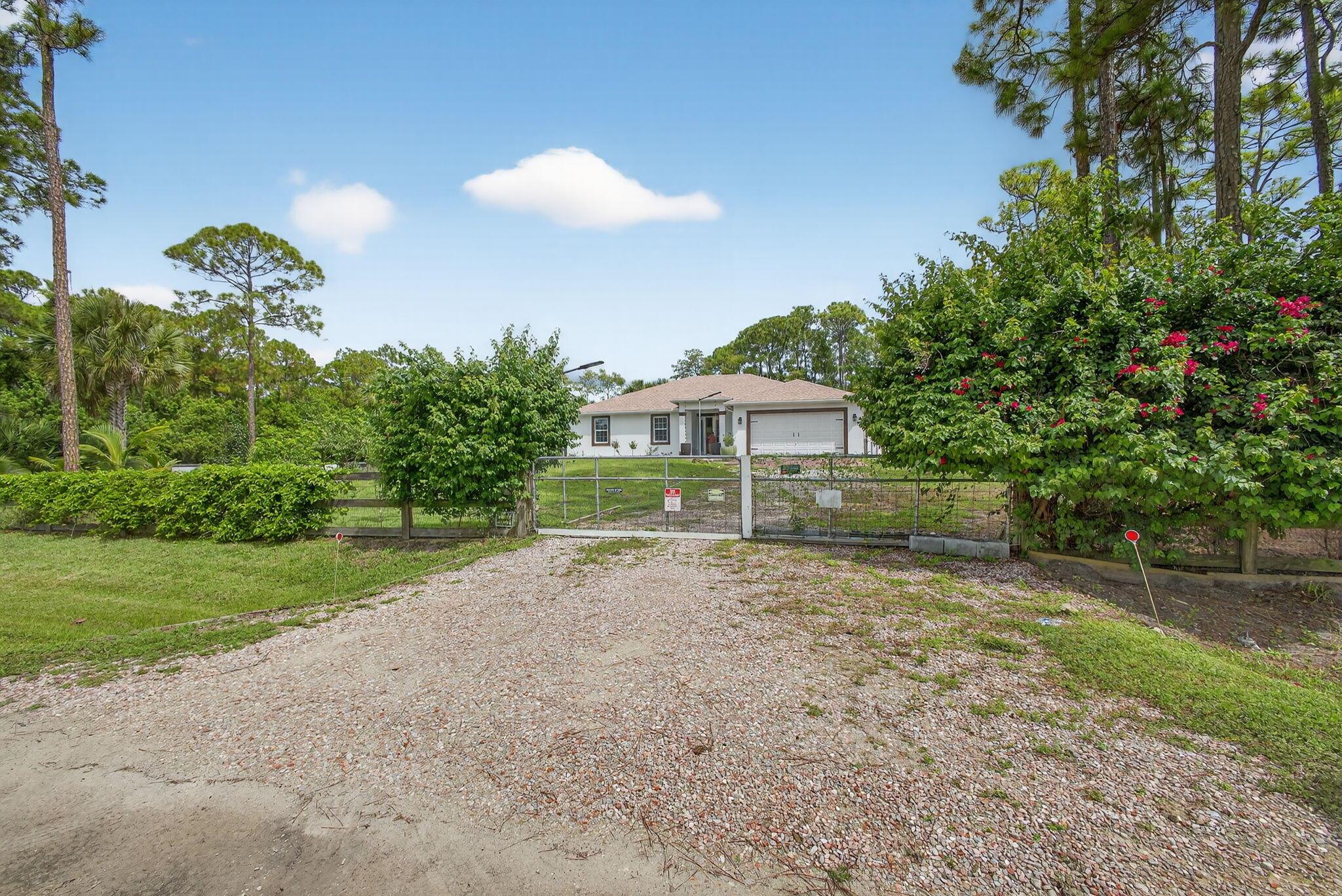 If you're searching for a rental that feels more like a private resort than a house, look no further. This fully upgraded 4‑bedroom/3‑bath CBS Synergy Home sits on a beautiful 1.34‑acre corner lot, a rarity in Loxahatchee, and delivers the perfect blend of luxury, privacy and Florida lifestyle. Step inside and be wowed by the open floor plan, soaring 9‑ft vaulted ceilings and oversized windows that flood the home with natural light. The gleaming wood‑look tile floors flow through the living areas and primary suite, while the guest rooms showcase sophisticated marble blue tile. A custom, hurricane‑rated front door with stained‑glass inserts makes a dramatic statement and bathes the foyer in colorful light. Throughout the home you'll find new chandel