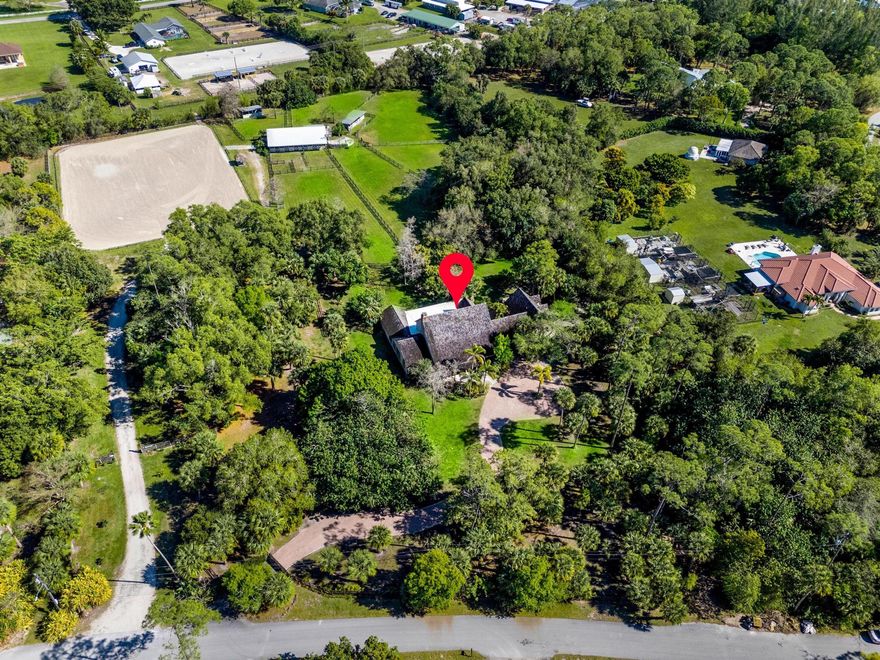 A rare equestrian estate in Wellington offering a combined 6.19 acres across two separately deeded parcels: one with the home the stable and paddocks, the other with the second driveway and arena. This 5-bed, 4-bath home blends timeless character and modern possibility. Once the original Stribling residence, it's ready to become your family's legacy. Enjoy daily equestrian living with 15 stalls, large and lush pastures, and a private arena steps from your door. Located in Little Ranches, you'll find elevated views, privacy, and close access to Wellington's world-class equestrian venues and amenities. The layout supports multi-generational living with the attached cottage house, ample spaces for gathering, retreat, and entertaining for everyone! Truly a one of a kind living experience!