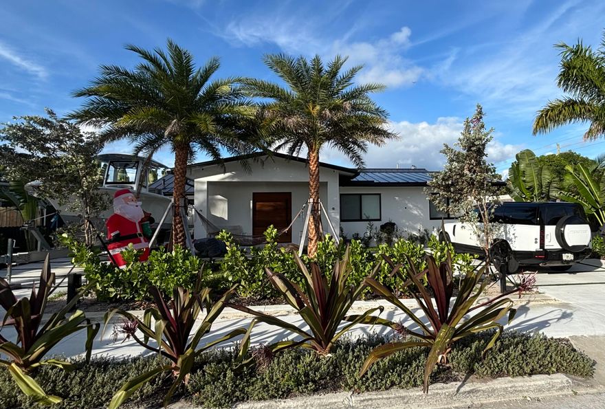 Introducing a meticulously redesigned residence where timeless elegance meets modern sophistication in the heart of West Palm Beach. This architect-designed home has undergone a comprehensive renovation, resulting in beautifully refined living spaces and exceptional attention to detail throughout.Offering approximately 2,223 square feet of air-conditioned living space, the home features five bedrooms, three bathrooms, and a private office, thoughtfully designed to seamlessly blend indoor and outdoor living for both everyday comfort and elevated entertaining.The interiors are highlighted by a luxurious primary suite with a vaulted ceiling, a spa-inspired bath, and a custom-designed wardrobe area. Each bedroom is appointed with custom closets, ensuring both style and functionality.