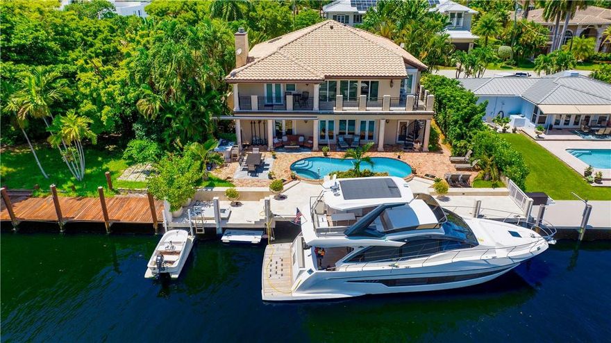 Surrounded by lush landscaping, this private gated residence, with a Chicago-brick motor-court entry, offers a majestic sense of arrival. The loggia & second-floor balcony overlook 75' of water-frontage, heated pool, and new summer kitchen with a retractable awning. Inside, this furnished, 4 bedroom plus den, European-inspired gem, with 4,689 sq.ft., features rich maple and granite-slab flooring, custom molding, architectural columns & archways, hurricane-rated windows/doors, and a new roof. Formal rooms downstairs include a dining room, breakfast room, wine cellar, office, game room, guest-bedroom, powder room, extra laundry room, and a cabana bath with storage. The primary suite offers water views, an exercise area, and a double vanity bath with soaking tub & walk-in shower.