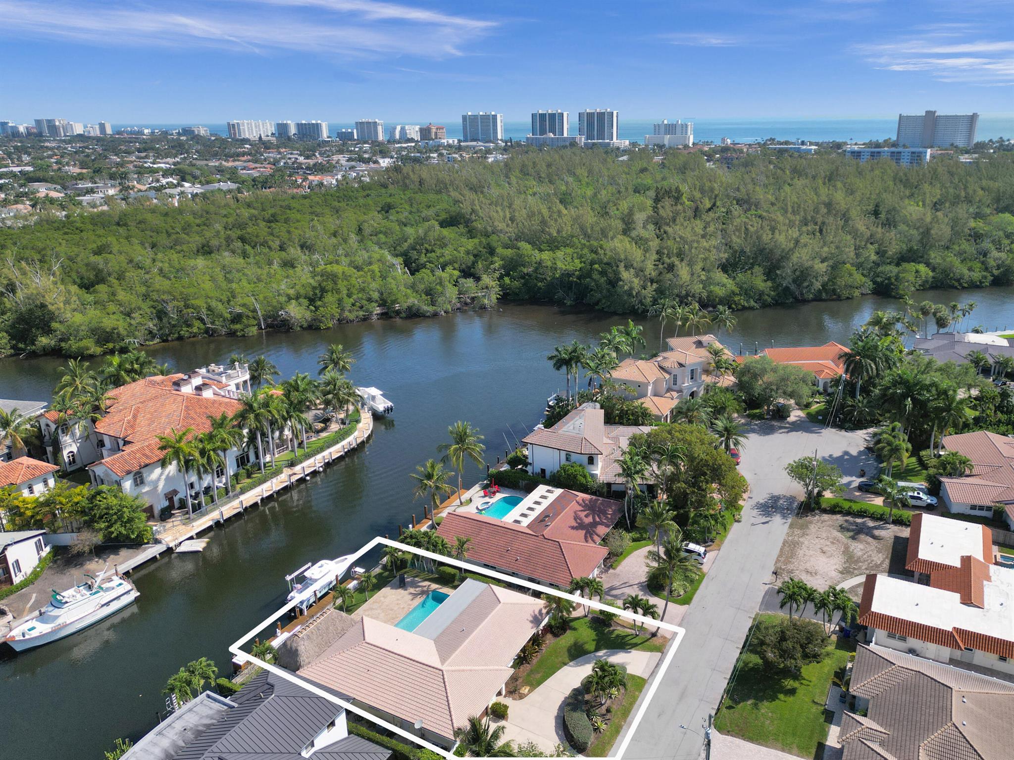 A Boater's Dream! Meticulously kept, beautiful 3 bedroom, 2 bathroom home in the sought after neighborhood of Little Harbor. The property impresses with 80 feet of water frontage in a no-wake zone, right off the Hillsboro river only moments to the Intracoastal, the Boca and Hillsboro Inlet. The property is also adjacent to a large cove which makes for a perfect turning basin and offers spectacular views of the estate homes of Little Harbor as well as the tranquil nature preserve of Deerfield Island. A new dock, new pilings and a 16,000 pound boat lift were added in 2022. With a great summer kitchen, oversized pool and a spacious tiki hut, the inviting outdoor area is perfect for entertaining. Inside, the home features a wonderful split floorplan, an updated kitchen facing the pool area, an
