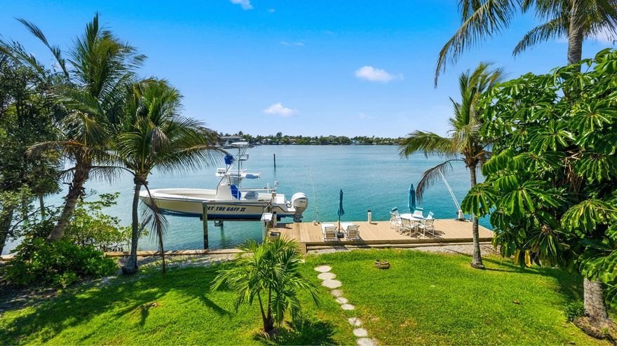 Discover Your Hidden Paradise! This charming riverfront property, spanning approximately 115 feet along the turquoise blue water of The Loxahatchee River, is nestled just south of Riverside. Enter through a mature Oak canopy on a private road leading to four residences situated on a point of the peninsula. This home is priced at land value but is move-in ready, offering you the perfect opportunity to plan renovations or build new and maximize the stunning panoramic river views. Built in 1976, the interior boasts a delightful charm, featuring an en-suite bedroom on the main floor and a primary suite on the second floor accompanied by a third bedroom. The two-car garage includes a full bath and kitchenette for potential guest quarters.  Enjoy the tropical yard adorned with multiple palm trees. The roof was updated in 2003 with composition shingles, and the dock, built in 2008, features a lift for a large center console. The seawall is also equipped with a cap.  Or get READY TO BUILD your dream waterfront home! Welcome to one of Jupiter's most extraordinary waterfront opportunities: 1/2 ACRE LOT boasting 115 feet of shimmering aqua-blue frontage on the desirable Loxahatchee River. Secluded among just five homes on an exclusive peninsula, this property is a true hidden gem, offering unparalleled privacy, sweeping water views, and a natural beauty that captivates even the most seasoned Jupiter locals. This remarkable property ensures easy access to the Jupiter Inlet, nearby sandbars, world-class fishing, and an elevated waterfront lifestyle.