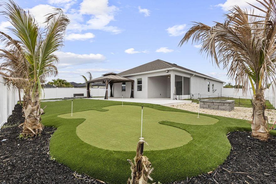 Step into your own private paradise with this upgraded 4/2/2 home featuring exceptional indoor-outdoor living on a canal. The exterior showcases a custom golf putting green with travertine tile and low-maintenance turf, a massive fire pit area, and even a mini basketball court. There is a carport perfect for all of the rec. toys, plus a spacious driveway that comfortably accommodates up to 6 cars. Inside, the home boasts of modern upgrades throughout, including brand-new appliances, luxury lighting, and upgraded tile. The kitchen is a standout feature, extra cabinetry, a custom backsplash, a coffee bar, and an island. The primary suite is designed with a tray ceiling, custom closet system and a master bath with a separate soaking tub. Don't miss your chance to own this one-of-a-kind home!