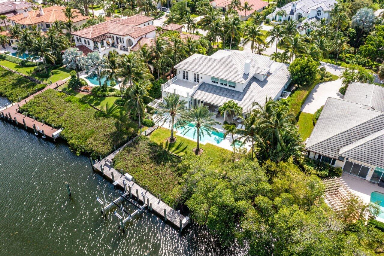 This magnificent move-in ready property situated on the waterfront boasts an exquisite design inspired by British Colonial style. As you enter, you are greeted by a grand foyer adorned with marble flooring that extends to the dining area. The formal living room with its impressive 24-foot ceiling is a sight to behold. Upstairs, a media/recreation room overlooks the living room, adding to the home's entertainment options. Enjoy a relaxed time in the eat-in gourmet kitchen and casual family area. The master suite is a luxurious retreat, featuring a sitting area, his-and-hers closets, and a built-in vanity. The bath is sumptuous, with a Jacuzzi and a large walk-in shower. Three well-appointed guest suites complete the sleeping quarters. New roof and second-floor balcony/patio installed 2024