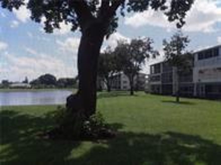 Investors!  Tenants in Place.  Back patio and side windows have an envious lake view.  This condo is improved -- wonderful kitchen with white cabinets recently installed. All the floors are the same -- handsome grey wood goes with everything! Corner unit has side and back windows -- five more windows than interior units!  Central air!  Ground floor entry gives easy access. Tenants would like to stay. Laundry on each floor. Invest in Boca's large guard-gated community with lots of amenities -- free bus, tennis, indoor & outdoor pools, golf, gyms, clubhouses, two houses of worship, movies, crafts, and more. Best times to visit are mornings between 9 and noon.