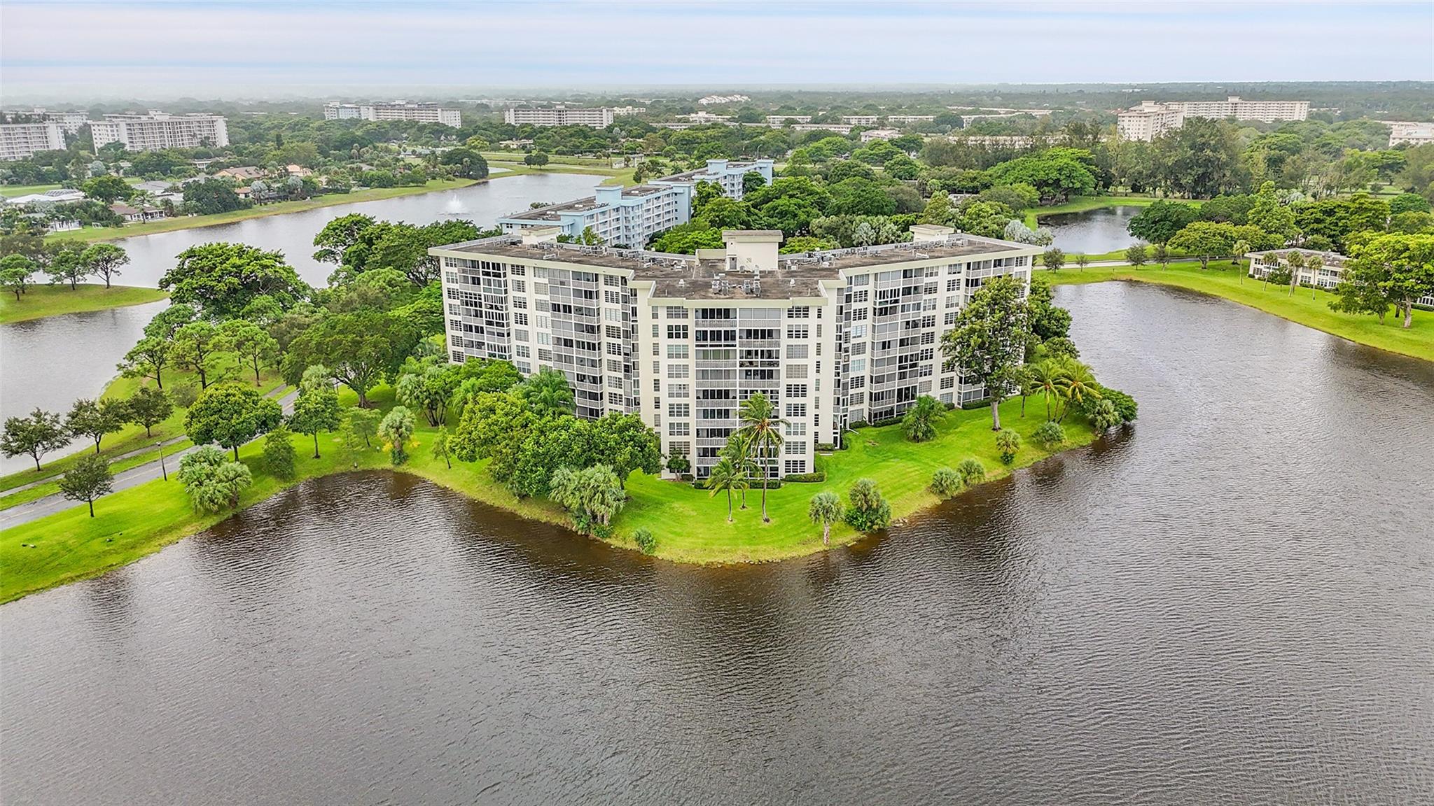 Corner unit filled with natural light, featuring extra windows in both bedrooms and bathrooms. Spacious 3/2 layout with porcelain tile throughout, granite countertops, shaker cabinetry, and stainless-steel appliances. Primary suite offers a walk-in closet with custom built-ins. Enjoy lake views through impact windows accented with plantation shutters. Conveniently located near I-95, shopping, grocery stores, and banking. Community provides laundry on every floor plus an additional storage area. Furniture available for purchase.