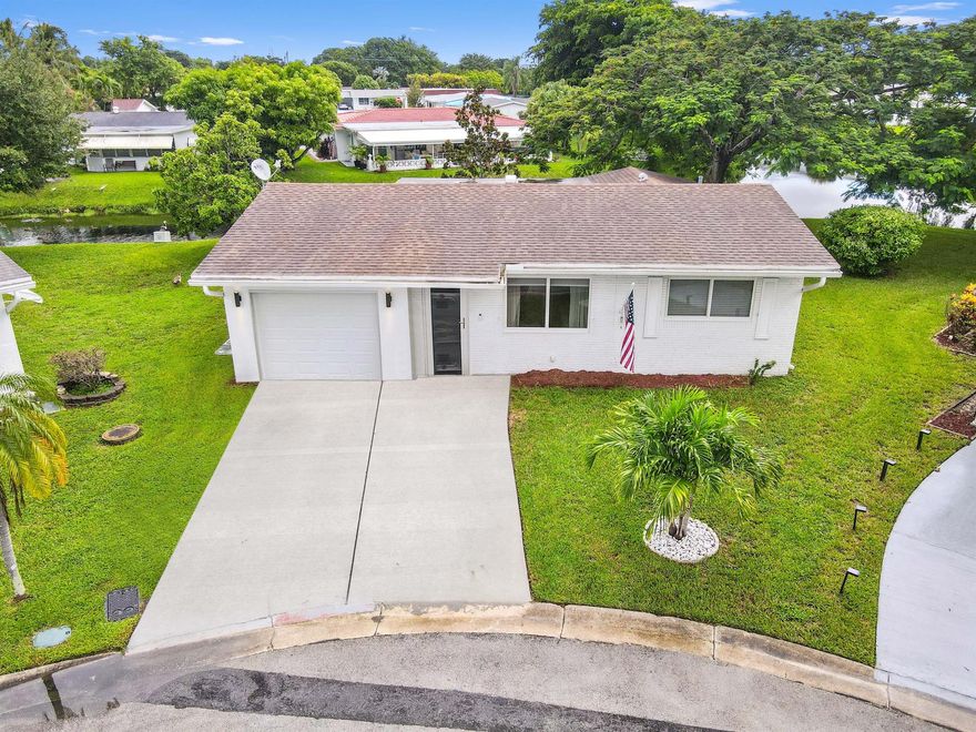 Welcome to this beautifully upgraded 1-story home in the desirable Paradise Gardens 55+ community. Nestled on a quiet cul-de-sac, this property offers stunning water views and easy entry-level living with a spacious Florida room. Featuring 2 beds &1 bath, the home boasts a 1-car garage, a 2018 roof, and a host of recent improvements. Enjoy peace of mind with 2024 upgrades, including new windows, hurricane protection, and a refreshed landscape with tree replacement. In 2023, this home received even more modern touches, such as a new AC, flooring, refrigerator, kitchen appliances, ceiling fans, a driveway extension, and an upgraded main water line. Perfect for those seeking comfort, security, and modern living in a tranquil setting! Don't miss the chance to make this your own!
