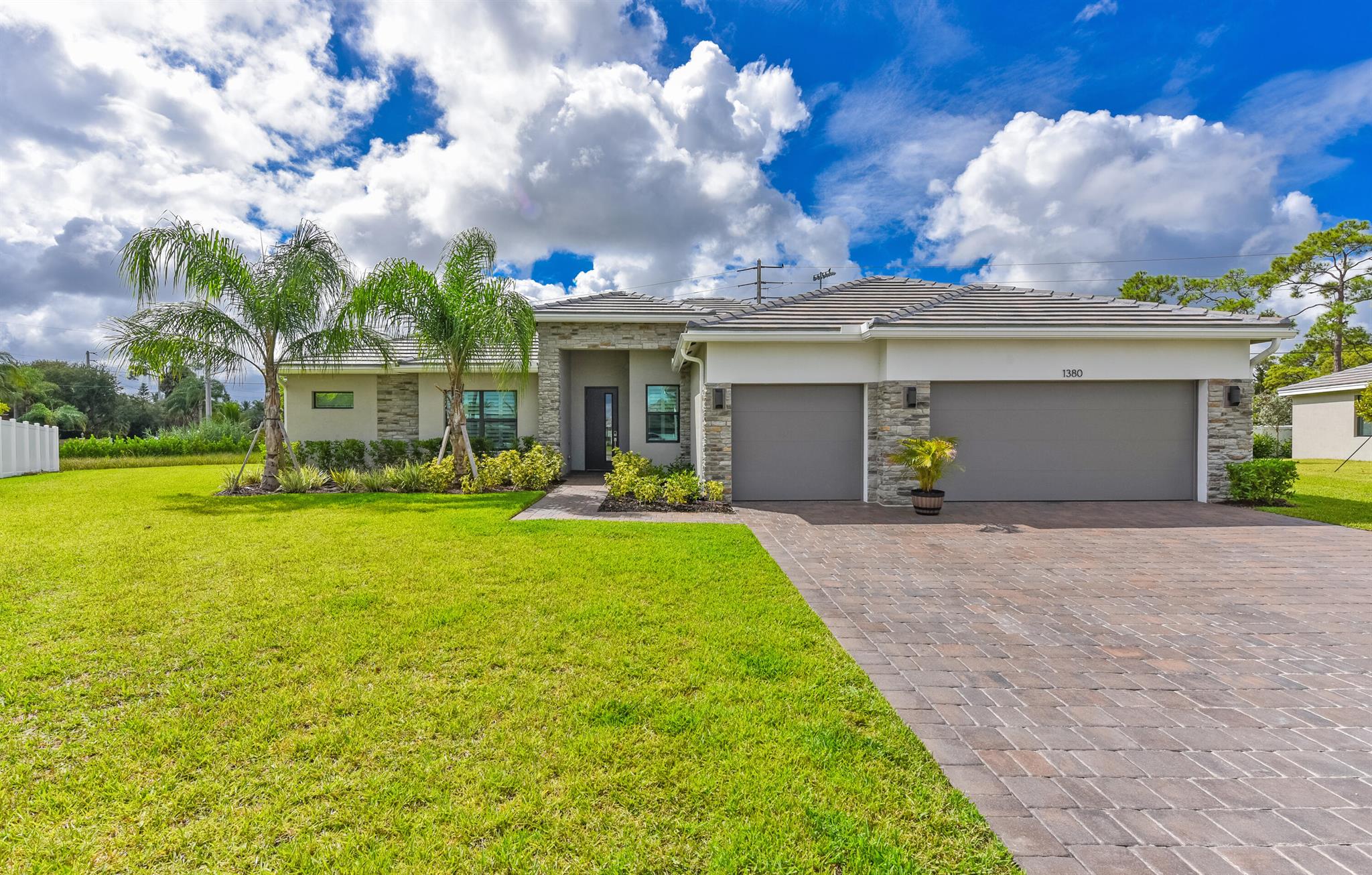 Peace of Mind in Palm City - Nearly New Home in The Oaks. Welcome to effortless living where this almost-new Bellister floorplan by D.R. Horton offers the perfect blend of comfort, style, and peace of mind. With 4 bedrooms, 3 bathrooms, and a flexible bonus space ideal for a home office, playroom, or gym, this thoughtfully designed split floorplan caters to both privacy and functionality. Built with convenience and security in mind, the home features impact windows, a three-car garage with extended driveway, and a fully fenced-in yard--making it truly better than new. The gourmet kitchen showcases solid surface countertops with a dramatic waterfall island, stainless steel appliances, and wood-look tile flooring throughout for a seamless blend of elegance and durability.