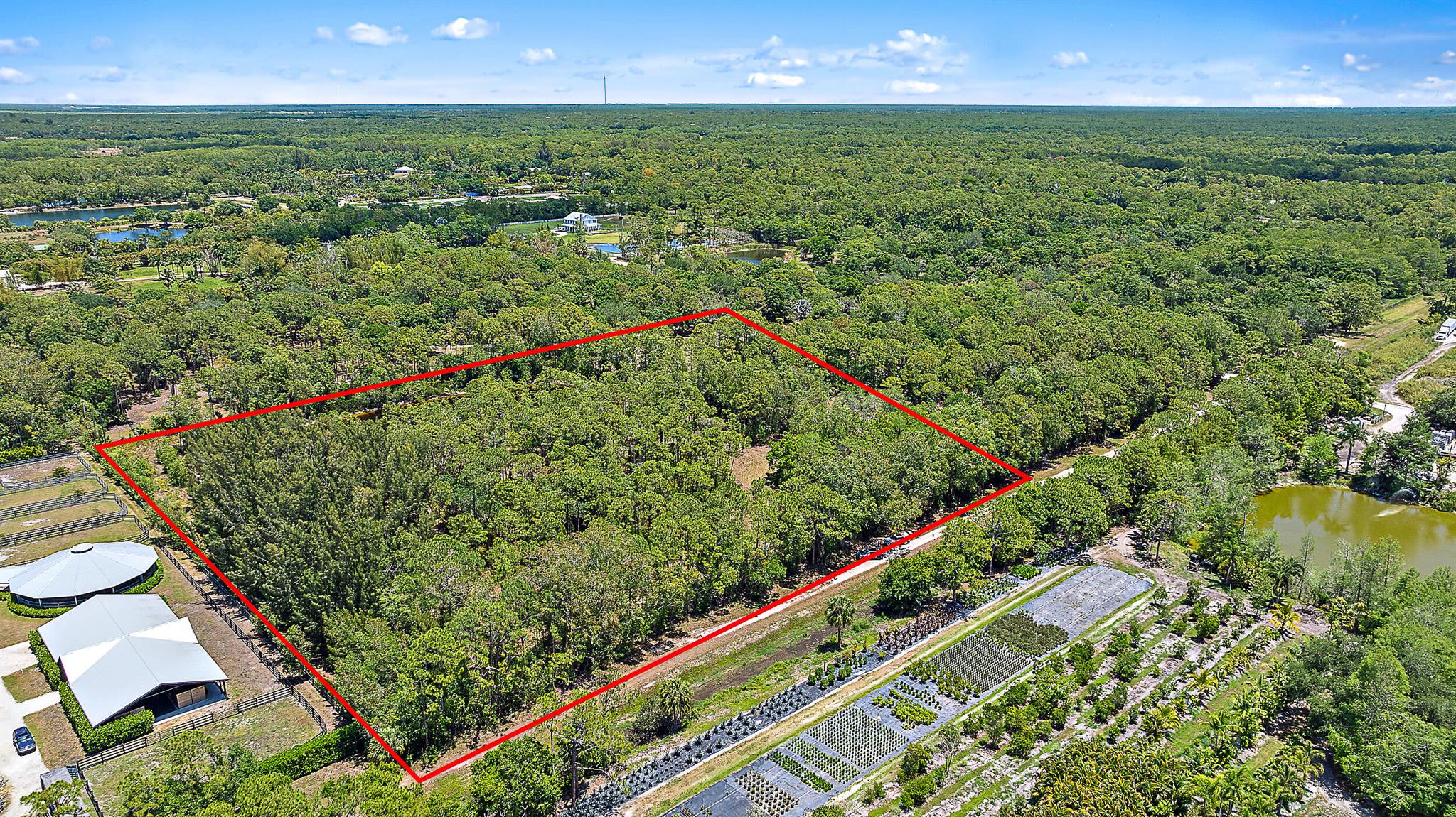 Located in one of the most desirable sections of Jupiter Farms, this 5.18-acre property offers exceptional opportunity to build your dream compound in a setting known for its larger, more private homesteads. The ground is high and dry with a pond adding both character and practical drainage.Situated next to a luxury equestrian facility and just down the road from a European-style nursery garden with a boutique shop & cafe, the setting blends rural lifestyle with a touch of elegance.Site design plans, an architectural floor plan, and elevation drawings available to expedite the building process.Property is fully fenced, underbrush previously cleared, and FPL has underground utilities to the property ready for hookup. The road to the property can be paved from 131st, or there
