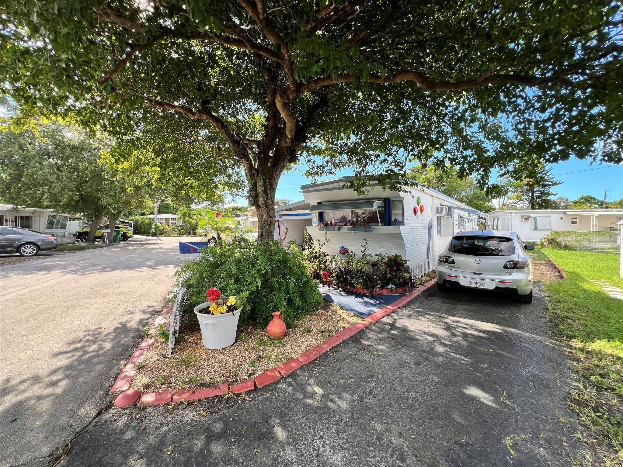 ***You own the land*** Best value in Park City!! A gorgeous mature tree shades the entrance to the property and welcomes you to the perfect place to call home. This well taken care of property ready for your own personal touches.. Large carport + Driveway with enough parking for 4+ cars. Minutes away from a public golf course, Costco, major groceries stores, restaurants, pharmacies, Target, Walmart, Home Depot & more. 10 minutes to FLL airport. 15 minutes to the beach. Park City offers 3 pools, shuffleboard and Mini putt putt golf all for the low HOA fee of $77 a month!! Office & community center onsite.