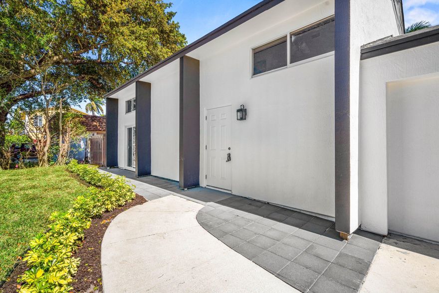 Fully renovated two-story home on a quiet street with a large fenced backyard offering space for a pool or recreational vehicles. This move-in ready property features a desirable primary bedroom on the first floor, vaulted ceilings, and a bright open living area filled with natural light. New hurricane-impact sliders and doors provide added security and energy efficiency. Includes washer and dryer hookup and a tankless instant hot water heater. Spacious yard offers privacy and room to entertain. Conveniently located near shopping, dining, beaches, major highways, and Palm Beach State College. No HOA.