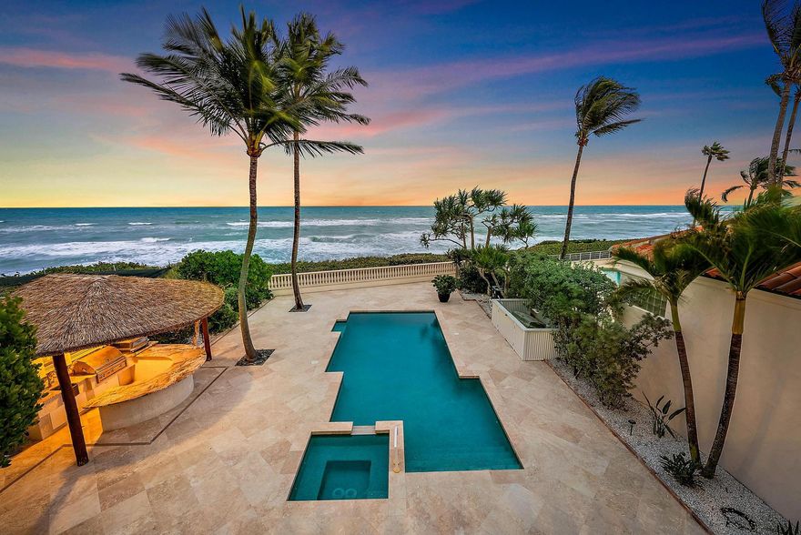 Paradise is found at Seven Hundred Ocean, an exclusive gated oceanfront community located along one of the most desirable luxury stretches of Ocean Drive in Juno Beach. Set on a rare 0.45-acre oceanfront lot, this two-story Mediterranean estate is directly on the sand, offering breathtaking sunrises, sweeping ocean views, and refreshing sea breezes.The residence offers approximately 6,152 sq. ft. under air with 7,945 sq. ft. total building area, featuring 5 bedrooms, an office/library, 6 full baths and 1 half bath, a butler's pantry, and a private elevator. Grand interiors include a formal living room with gas fireplace and a spacious family room overlooking the Atlantic Ocean, creating seamless indoor-outdoor living.