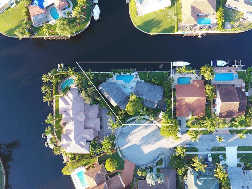 Located in very desirable Estoville in East Boca, and situated on a fantastic cul de sac, this incredible home is on 178ft of water with ocean access and includes a 50' dock. There are 4 spacious bedrooms. The master suite has his and her bathrooms and closets and is located on the second floor for complete privacy, with a large deck overlooking the magnificent water views. The home has a split floor plan downstairs and over sized living spaces. A separate dining room and living room with vaulted ceilings gives this home a lot of character. A fantastic, large yard with plenty of grass and a great pool area makes for perfect Florida living.