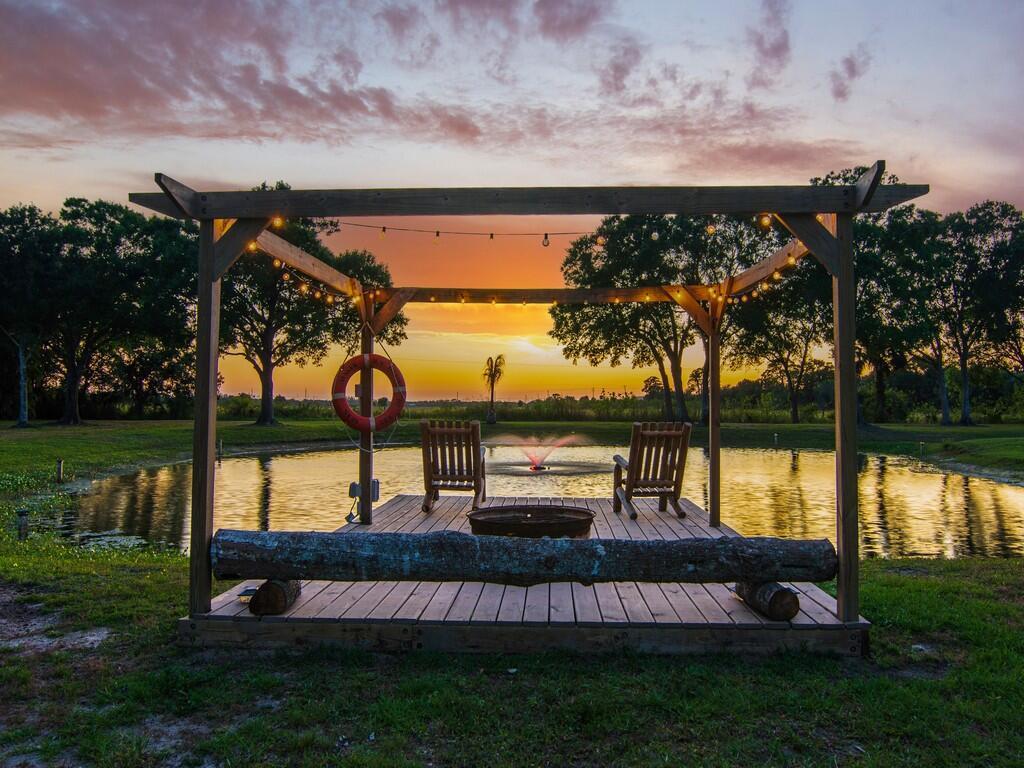 Idyllic estate sprawled over 4.75 ac w/voluntary HOA. Shaded front porch gives off quiescent vibes and large screened back porch with outdoor kitchen provides for excellent entertaining area and viewing of romantic sunsets. Brand new resort-like salt water heated pool w/ spa and full automation overlooks fish stocked pond. Hurricane rated windows, vaulted ceilings, high grade finishes and spacious room. Each bedroom is en-suite. Master quarters offer two large walk-in closets, separate large tub and shower, double sinks and WC. Plenty of closet space throughout. Huge pole barn and fire pit.
