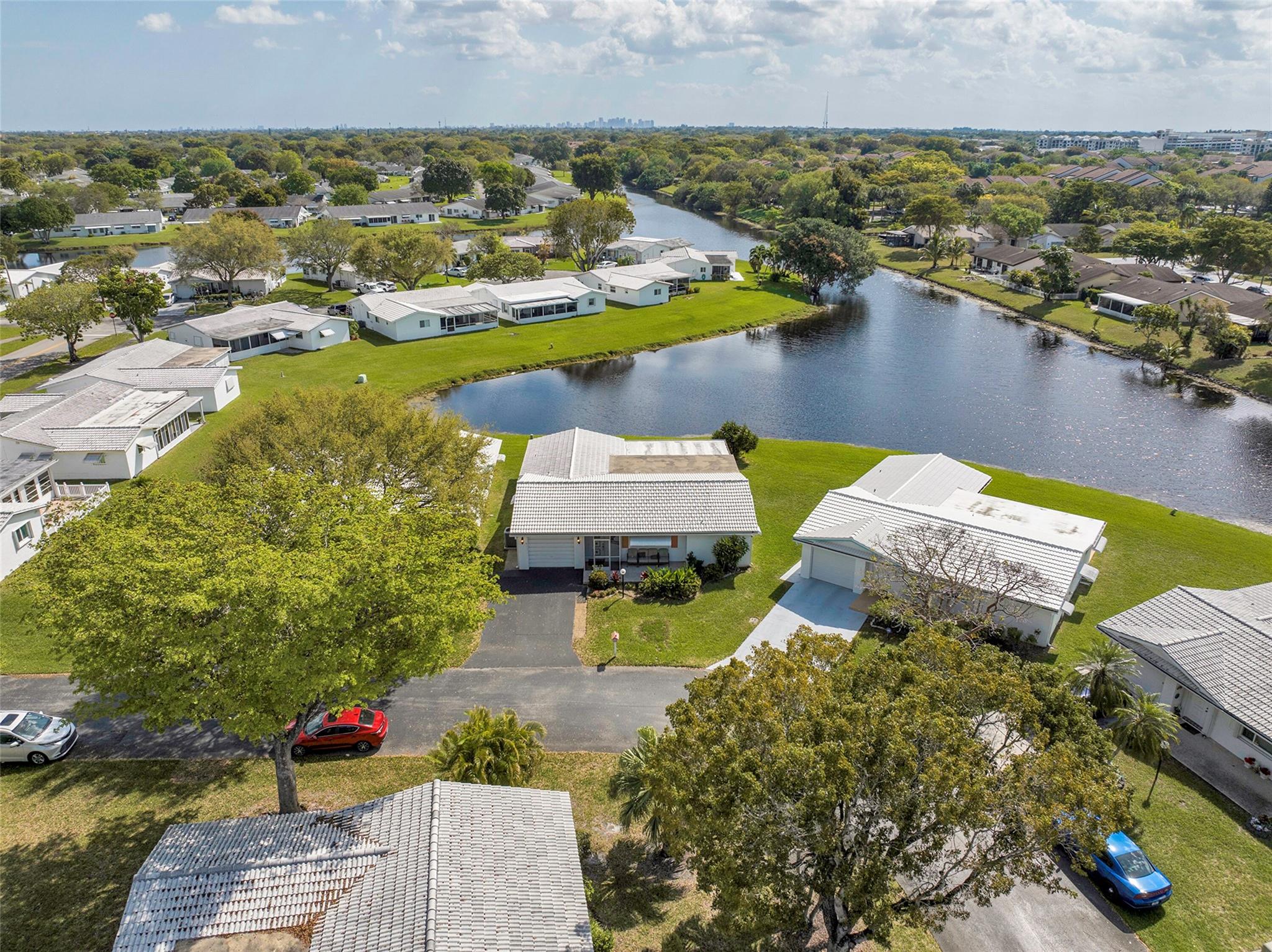 Discover serene waterfront living in this stunning 2-bed, 2-bath home on a wide water lot in a desirable 55+ community. Enjoy breathtaking views from the comfort of your living space, enhanced by all-impact windows/doors and stylish zebra window treatments. The modern kitchen boasts newer stainless steel appliances, perfect for effortless cooking and entertaining. Spacious bedrooms provide comfort and privacy, while updated bathrooms add a touch of luxury. With tranquil water vistas and a peaceful atmosphere, this home offers both beauty and security in an active, welcoming community. Roof was installed in 2023. A/C installed in 2015. Knockdown ceilings and crown molding throughout. Don't miss this exceptional opportunity to call the extended LAKEVIEW Model with a bonus room home!