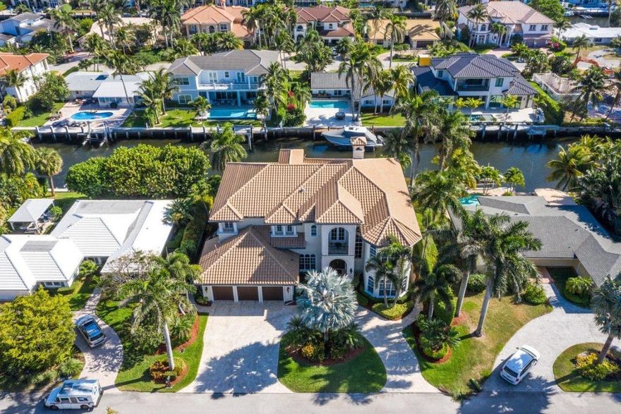 This Spectacular Estate is South Facing on 95 feet of Deepwater, 70-foot dock with 6458 sq. ft. of interior space, 6 spacious ensuite bedrooms, 6.5 baths plus 3rd floor Theatre Room & elevator. Entertain in Paradise by the freeform pool and spa with tranquil waterfall, summer kitchen, spacious lanai, and breathtaking views! This Estate has been meticulously maintained...shows like a model! The gourmet kitchen features 2 refrigerators, 2 freezers, 2 dishwashers, gas burning stove, and opens to Family Room. There are two ensuite bedrooms on first floor and a magnificent master suite on second floor that opens to 2 outdoor terraces overlooking the water. This estate is complete with Impact Windows and Doors, Roof (March 2017), all closets have custom built-ins, Generator 20K, 3 balconies and much, much more!! Walking distance to the Beach! 
Furniture negotiable! Excluded from sale: Jukebox, downstairs South bedroom blue draperies, Bronze Boy & Girl Statue at front entry by fountain.