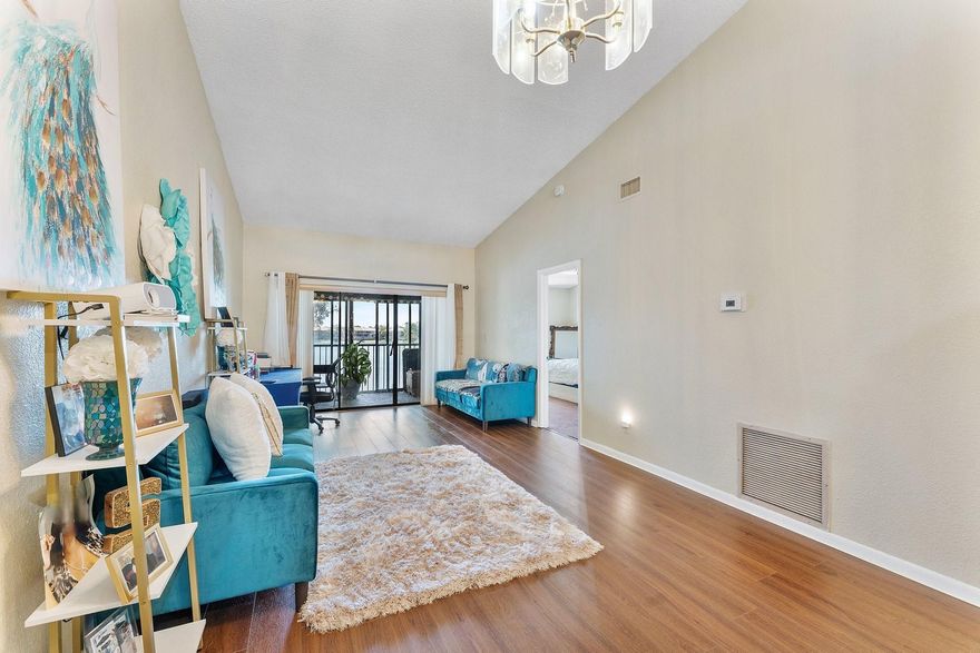 Enjoy peaceful lake views from this inviting 2-bedroom, 2-bath condo in Mira Lago, offering 1,075 square feet of well-planned living space. This light-filled residence features an open layout with volume ceilings that create an airy feel throughout. The primary suite includes a walk-in closet and an updated bath with a tiled shower and floor. Wood flooring enhances the main living areas, and the kitchen includes a brand-new stove. Relax on the screened patio overlooking the water. Located in a gated community with a pool and convenient access to shopping, dining, and well positioned near major routes.