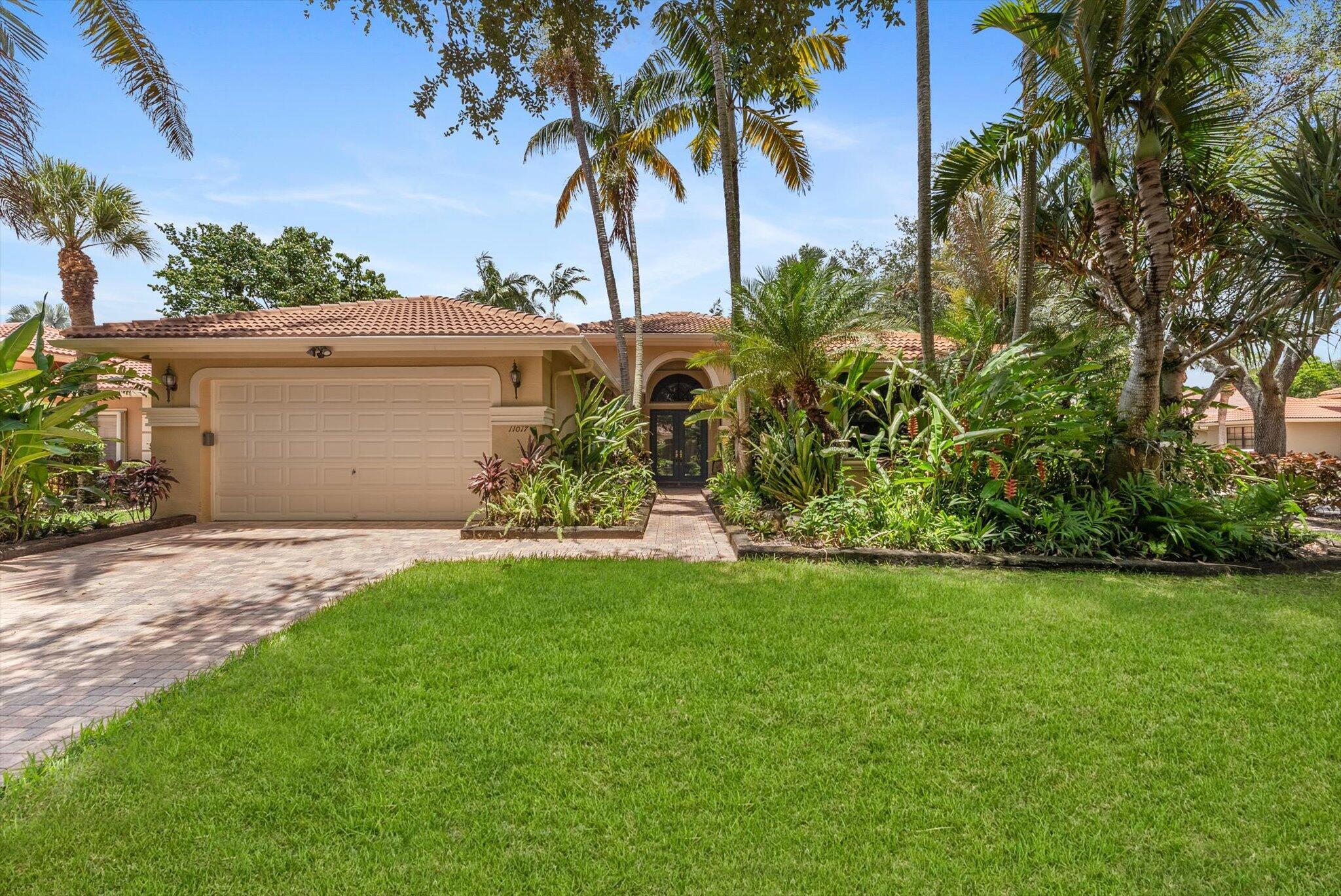 Welcome to your personal oasis, an impeccably maintained and move-in ready residence nestled in one of the most vibrant 55+ communities. From the moment you arrive, you'll be captivated by the lush tropical gardens, exotic fruit trees (including Portuguese grapes, mango, starfruit, and passionfruit), and a serene backyard that offers both tranquility and resort-style entertaining. Enjoy Florida living at its finest with your private dipping pool equipped with jets, spa features, and an air blower system. Host unforgettable gatherings in the fully equipped outdoor summer kitchen with sleek stainless steel appliances. This immaculate 3-BR plus den/office, 2.5-BA home showcases tasteful updates throughout: engineered hardwood and tile flooring, a spacious chef's kitchen with stainless steel
